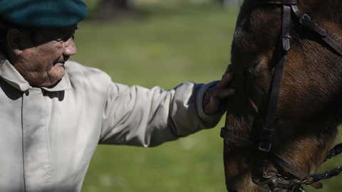 Oscar Villafane pets Coco the horse at the San Jose Home for seniors where he lives in Tandil Argentina, Wednesday, Sept. 15, 2021. The residence took in the horse during the COVID-19 lockdown to cheer up their elderly residents. (AP Photo/Natacha Pisarenko)