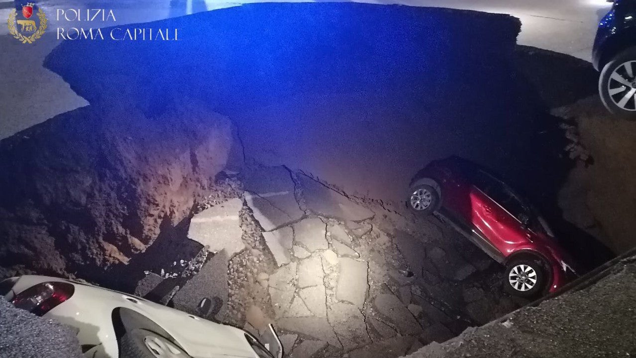 28.03.2024, Italien, Rom: Autos liegen in einem riesigen Erdloch. Das ungef&auml;hr zehn Meter tiefe Loch mit einem Durchmesser von ebenfalls zirka zehn Metern hatte sich aus bisher ungekl&auml;rter Ursache in der Nacht zum 28.03.2024 aufgetan und zwei geparkte Autos in die Tiefe gerissen. (Polizia Roma Capitale/dpa)
