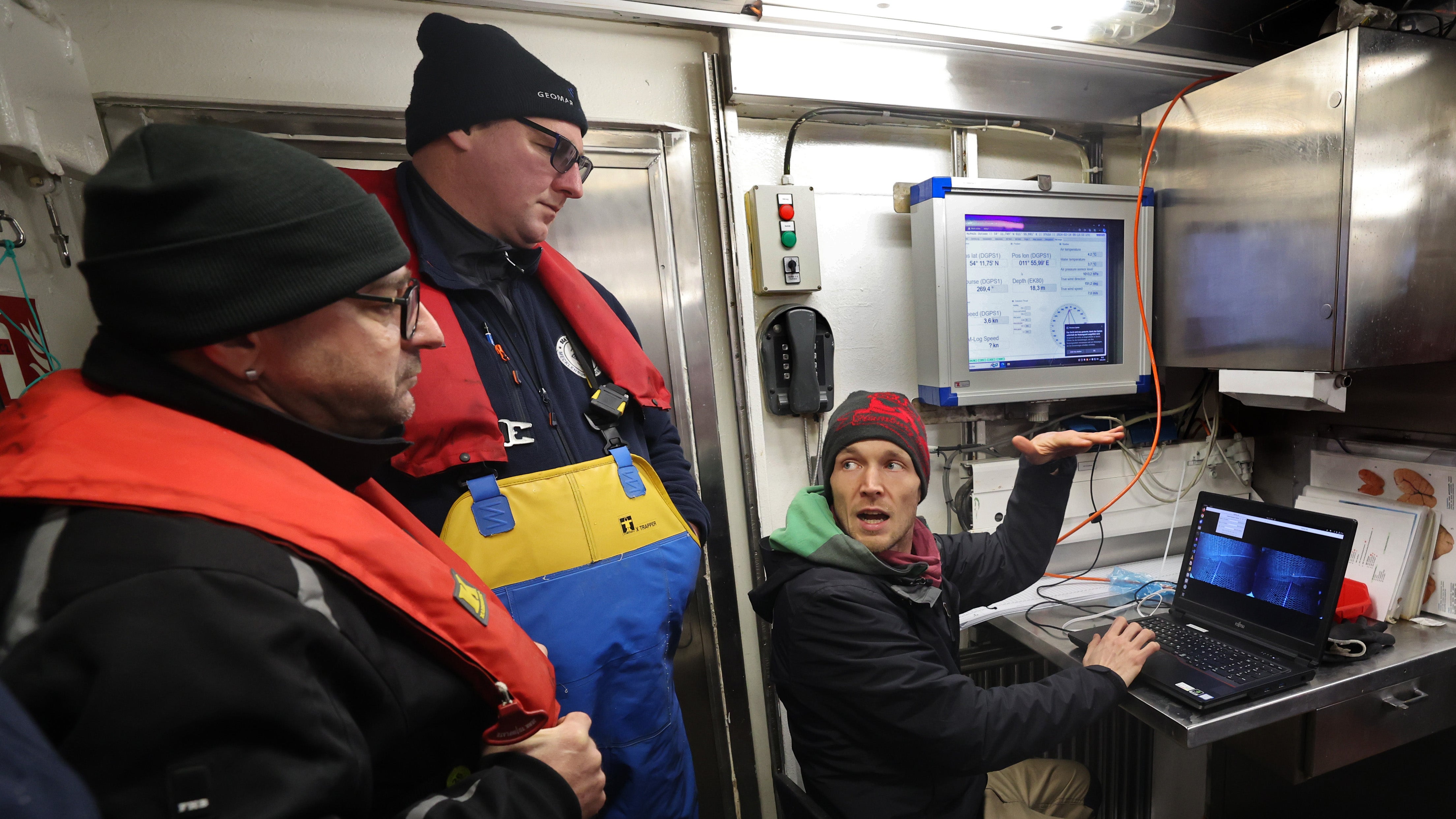 14.02.2024, Mecklenburg-Vorpommern, K&uuml;hlungsborn: An Bord des Fischereiforschungsschiffes Solea auf der Ostsee besprechen Kai Handke (l-r), Fischer aus Korswandt (Usedom), Mathias Labahn, Fischer aus Freest, und Mathis Mahler vom Th&uuml;nen-Institut f&uuml;r Ostseefischerei aktuelle Aufnahmen von Videokameras in einem Fischernetz. (Bernd W&uuml;stneck/dpa)

