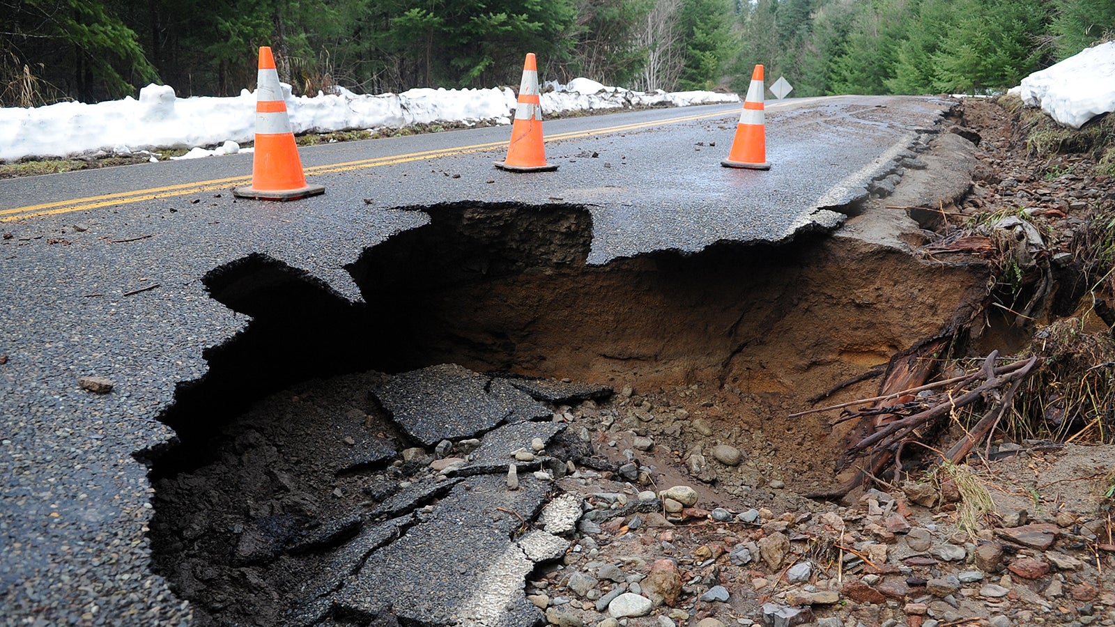 A sinkhole claims a piece of paved road in the Cascade Mountains.