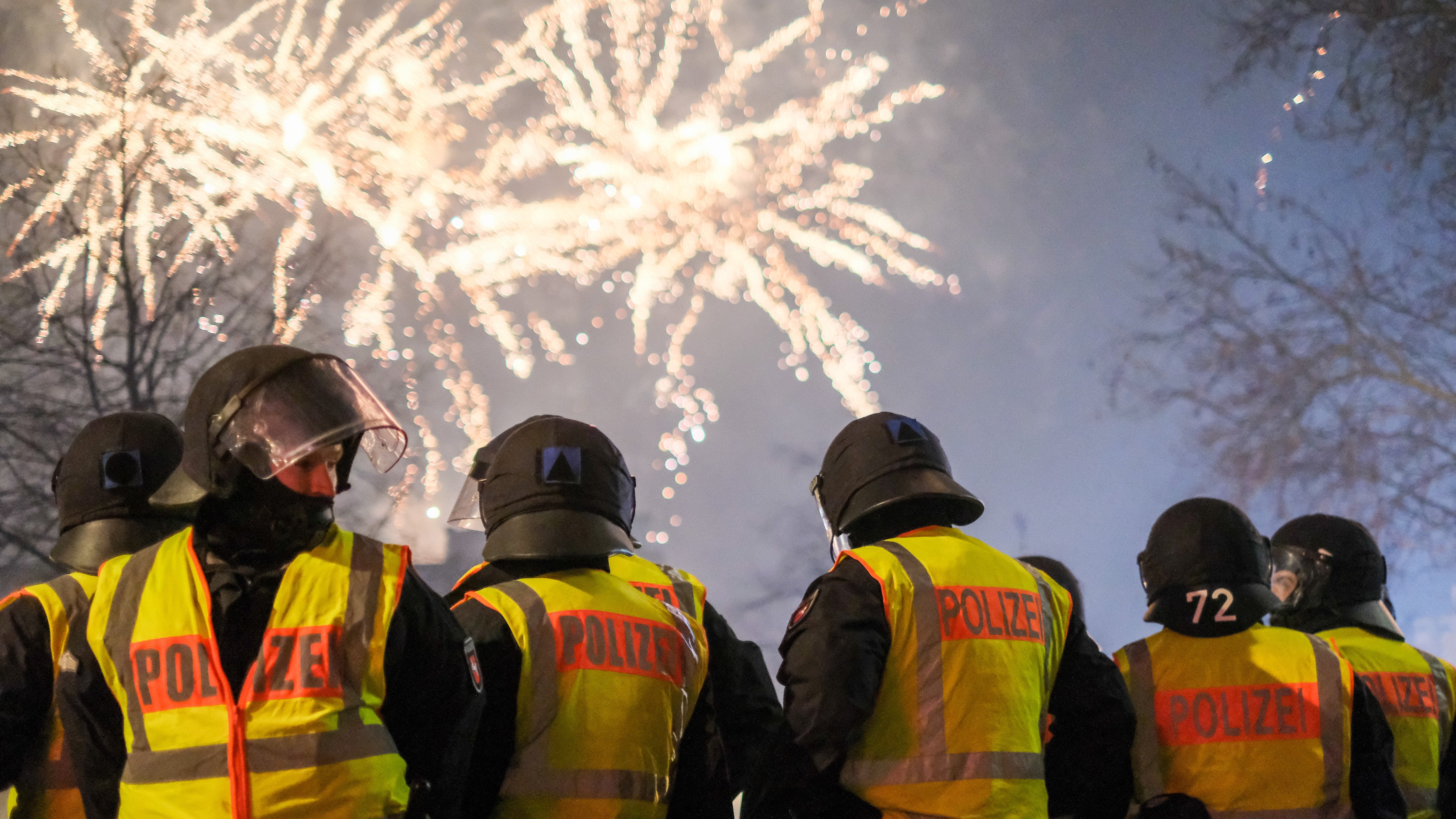 ARCHIV - 31.12.2018, Niedersachsen, Hannover: Beamte stehen am Steintor, wo das Z&uuml;nden von Feuerwerk in den vergangenen Jahren verboten war, und beobachten ein Feuerwerk in der Ferne. In Teilen der Innenstadt Hannovers soll zur Silvesternacht 2022/2023 erneut das Abbrennen von Feuerwerk verboten werden. (zu dpa: Wieder weniger Einschr&auml;nkungen f&uuml;r Silvester-Feuerwerk) Foto: Clemens Heidrich/dpa +++ dpa-Bildfunk +++

