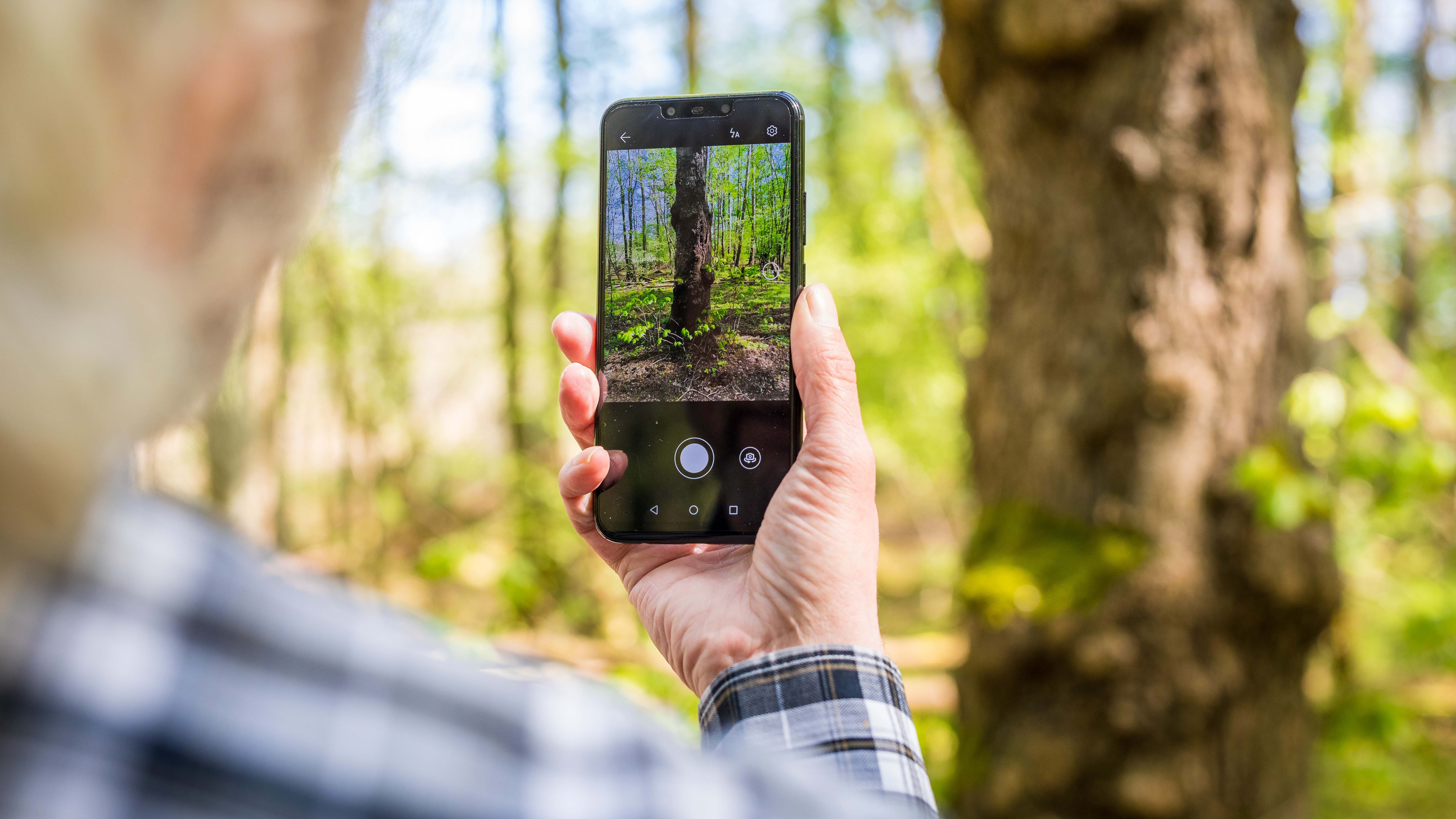 09.05.2021, Niedersachsen, Winsen (Aller): Rolf Jantz, der zu der Community der &acute;Naturgucker&ordf; geh&circ;rt, fotografiert mit einer App auf seinem Smartphone einen Baumstamm im Landkreis Celle, um den Baum zu bestimmen. Oft aus Mangel an Alternativen erkunden viele Menschen in der Pandemie ihre n&permil;here Umgebung. Das Handy kann dabei helfen, Blumen, B&permil;ume, V&circ;gel oder Insekten kennenzulernen. In der Community naturgucker.de werden Apps ebenfalls zur Erfassung und Meldung von Beobachtungen verwendet. (zu dpa "Die Natur entdecken mit dem Smartphone - Apps boomen in Corona-Zeit") Foto: Moritz Frankenberg/dpa +++ dpa-Bildfunk +++