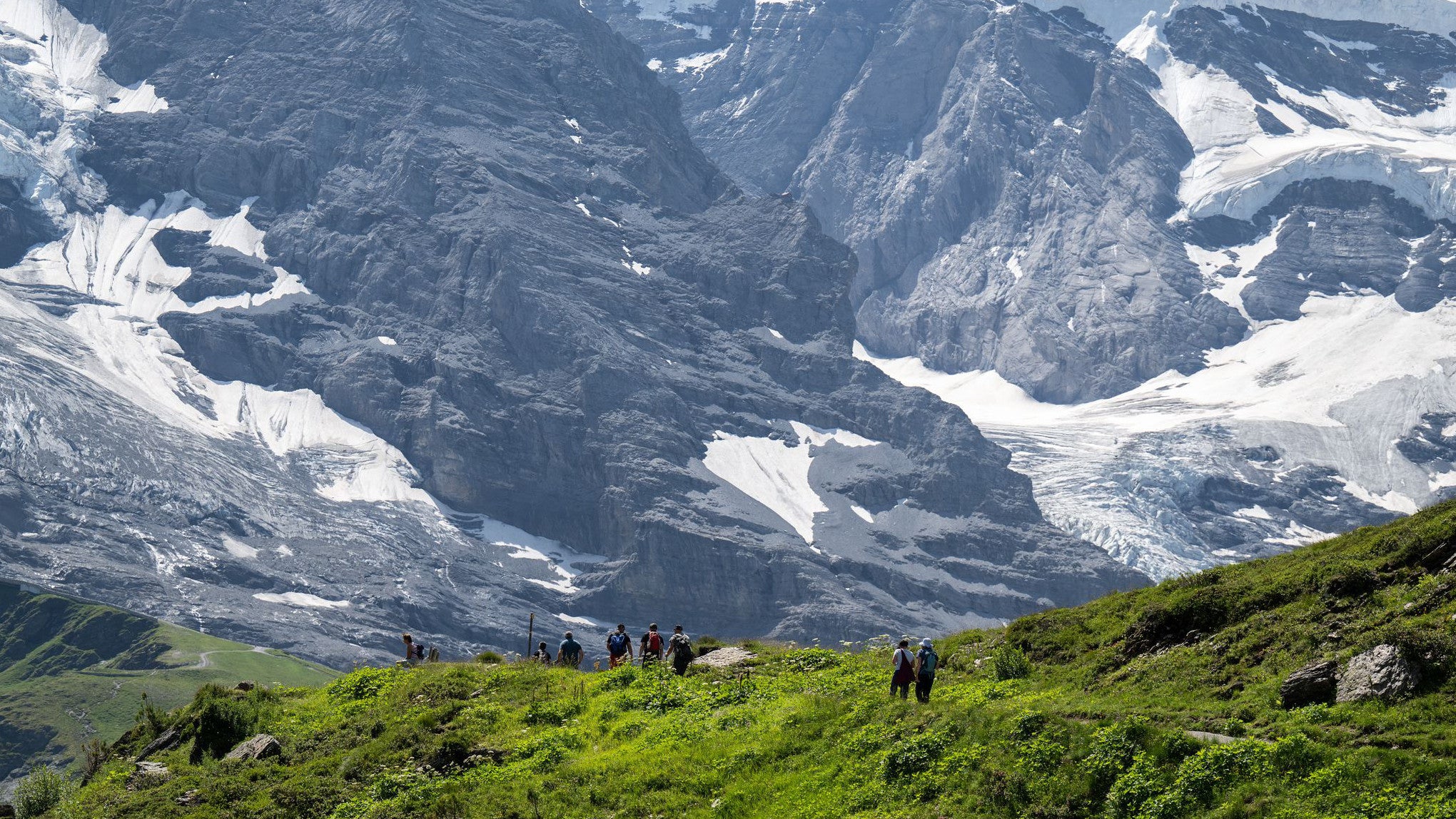 03.07.2022, Schweiz, Grindelwald: Wanderer gehen mit Blick auf die Sphynx auf dem Panoramaweg auf der Passh&ouml;he Kleine Scheidegg entlang. (Peter Schneider/KEYSTONE/dpa)