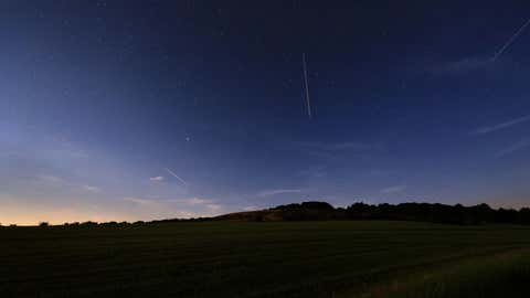 19.07.2024, Bayern, Bischofsheim: Unter einem Sternenhimmel liegt die Landschaft nahe des Kreuzbergs. Das Biosphärenreservat Rhön ist als Sternenpark anerkannt. (Karl-Josef Hildenbrand/dpa)