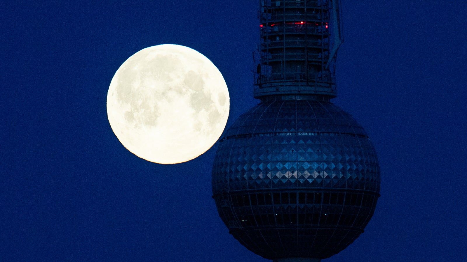 Ein sogenannter Supermond steht hinter dem Fernsehturm. Ein Supermond entsteht, wenn der Mond bei Vollmond der Erde besonders nahe ist. Foto: Christophe Gateau/dpa
