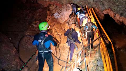 In this undated photo released by Royal Thai Navy on Saturday, July 7, 2018, Thai rescue team members walk inside a cave where 12 boys and their soccer coach have been trapped since June 23, in Mae Sai, Chiang Rai province, northern Thailand. The local governor in charge of the mission to rescue them said Saturday that cooperating weather and falling water levels over the last few days had created appropriate conditions for evacuation, but that they won't last if it rains again. (Royal Thai Navy via AP) 
Credit: AP 