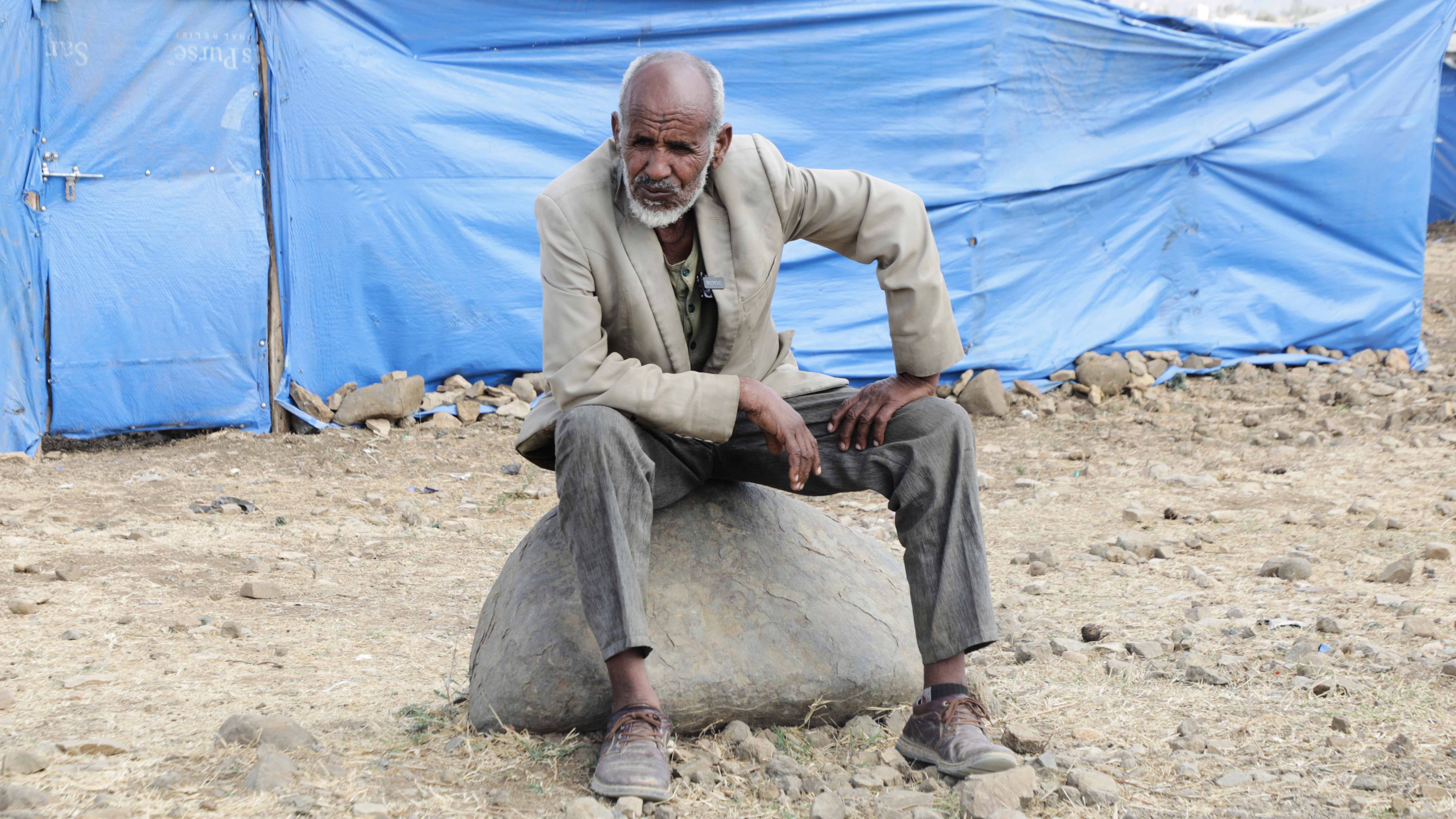 Haile Tsege, 76, sits on a rock in the Sebacare internally displaced persons (IDPs) camp, on the outskirts of Mekele, Tigray region, Ethiopia, Wednesday, Feb. 12, 2025. (AP Photo/Alexander Mamo)