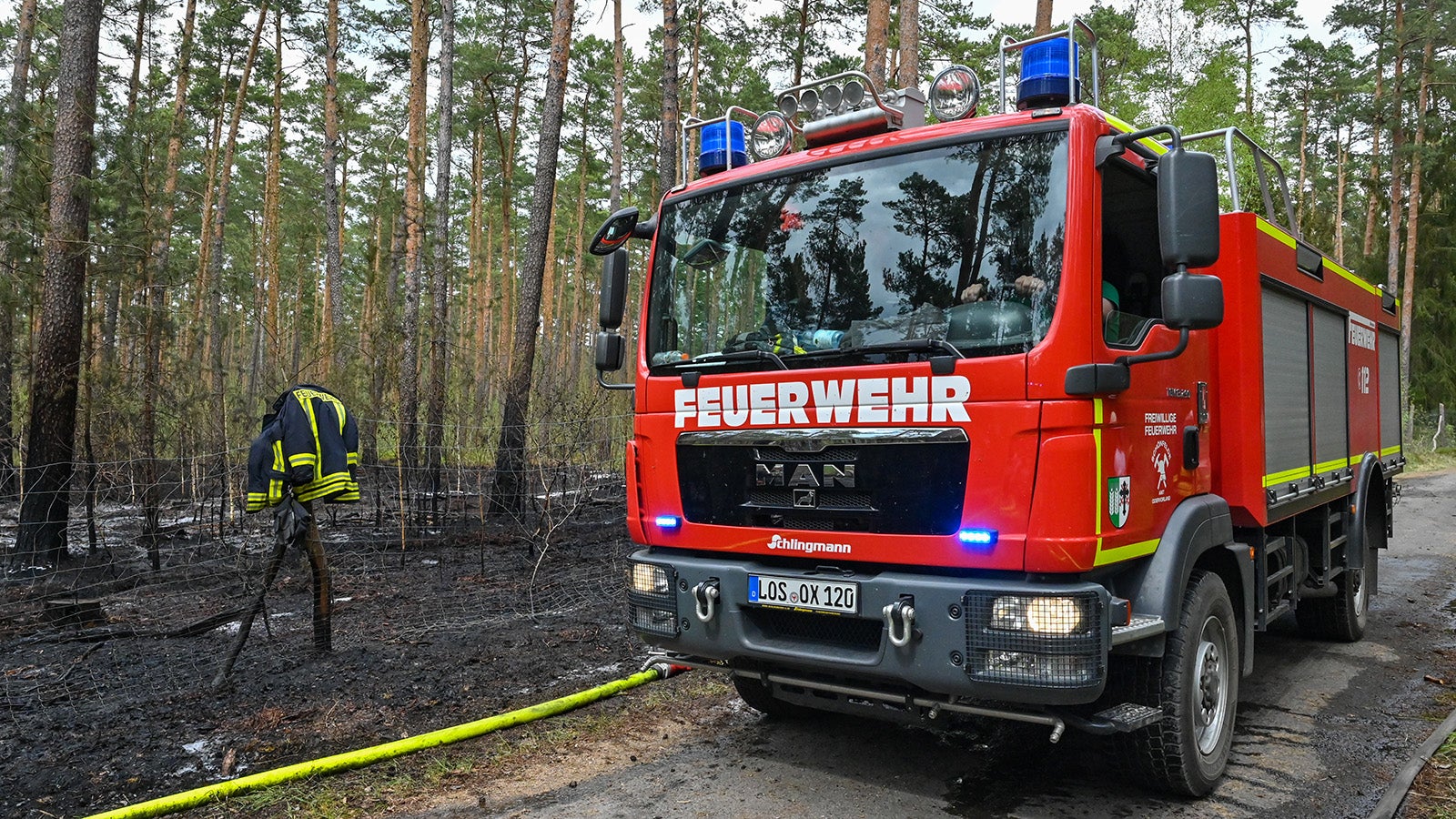 07.05.2022, Brandenburg, Briesen: Ein L&ouml;schfahrzeug der Freiwilligen Feuerwehr steht neben dem gel&ouml;schten Waldbrand. Mit den steigenden Temperaturen hat in Brandenburg die Gefahr von Waldbr&auml;nden stark zugenommen. (zu dpa: &laquo;&laquo;Da ist was&raquo; - Sensoren als scharfes Auge zur Waldbrand&uuml;berwachung&raquo;) Foto: Patrick Pleul/dpa +++ dpa-Bildfunk +++