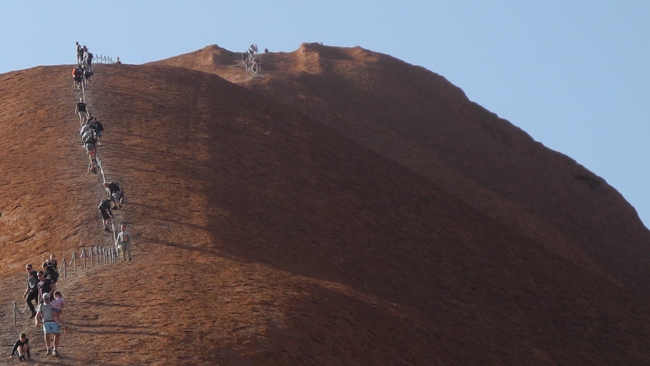 Touristen klettern Australiens &laquo;Heiligen Berg&raquo;, den Uluru (Ayers Rock) hinauf.
