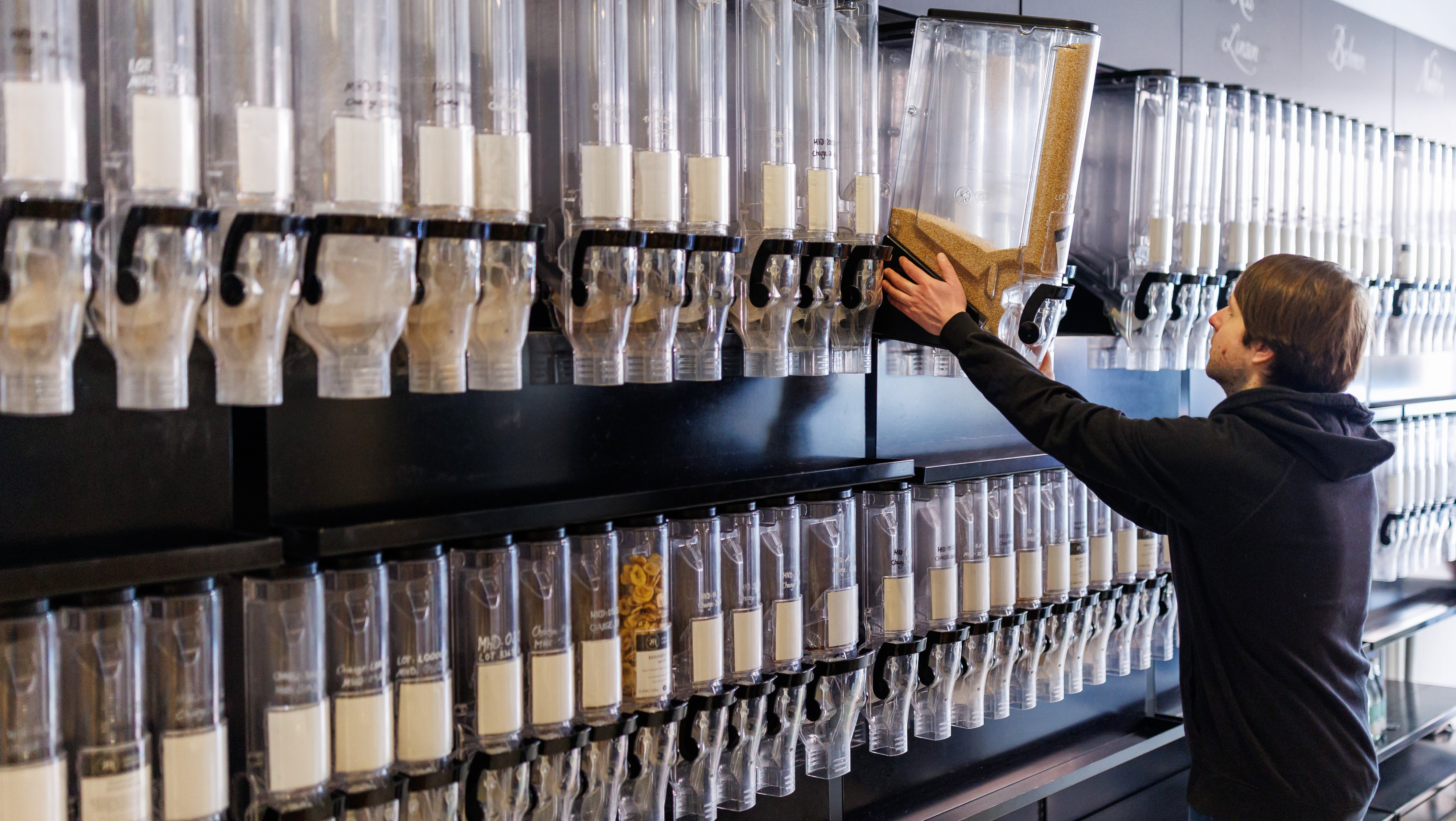 PRODUKTION - 16.03.2023, Bayern, N&uuml;rnberg: Arthur Koenig, Gesch&auml;ftsf&uuml;hrer des Unverpackt-Ladens Zero Hero, plaziert im Gesch&auml;ftsraum einen Lebensmittelspender. Die Unverpackt-L&auml;den in Deutschland stecken wegen steigender Lebensmittelpreise und eines ver&auml;ndertes Konsumverhaltens nach Corona in der Krise. Etliche Gesch&auml;fte mussten im vergangenen Jahr aufgeben. Rund 270 Unverpackt-L&auml;den gibt es nach Zahlen des Verbands der Unverpackt-L&auml;den zurzeit in Deutschland - etwa 70 weniger als noch Anfang 2022. (zu dpa &laquo;Schlechte Zeiten f&uuml;r Unverpackt-L&auml;den&raquo; und "Unverpackt-L&auml;den in der Krise - Konzept ohne Zukunft?") Foto: Daniel Karmann/dpa +++ dpa-Bildfunk +++