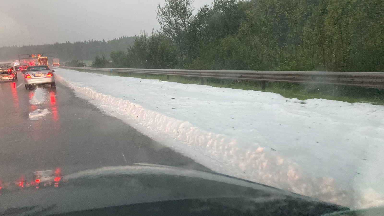 26.07.2021, Bayern, Irschenberg: Eine dicke Schicht mit Hagelk&ouml;rnern liegt auf dem Randstreifen der Autobahn 8. Heftige Gewitter mit Starkregen und auch Hagel haben am fr&uuml;hen Montagabend in S&uuml;dbayern erneut f&uuml;r &Uuml;berschwemmungen gesorgt. Foto: Jutta Steinhoff/dpa +++ dpa-Bildfunk +++