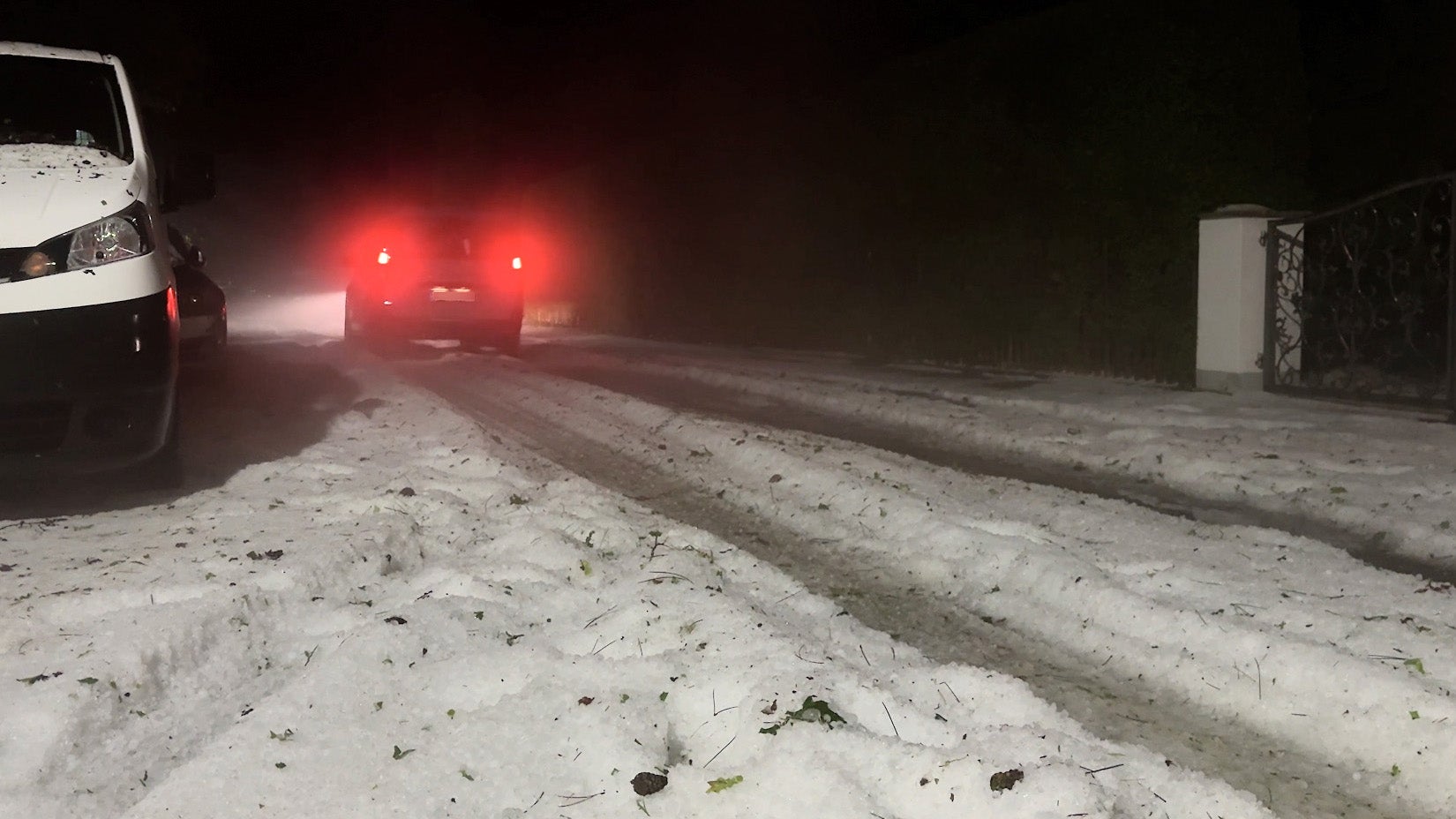 13.07.2024, Bayern, H&ouml;henkirchen-Siegertsbrunn: Ein Auto f&auml;hrt wie durch eine Winterlandschaft mitten im Sommer. Erst zog eine Superzelle in die Richtung, die sich dann zur Gewitterfront entwickelte. Diese brachte einen Downburst mit sich und Hagelmassen fielen auf die Landschaft. Die etwa ein bis zwei Zentimeter gro&szlig;en K&ouml;rner lagen auf Stra&szlig;en und Wegen teilweise bis zu 30 Zentimeter hoch. Selbst R&auml;umfahrzeuge und Schneeschaufeln kamen zum Einsatz, um die wei&szlig;en Massen zur Seite zu schieben. Der zus&auml;tzlich gefallene Starkregen sorgte zum Teil f&uuml;r &Uuml;berflutungen, weil das Wasser nicht mehr ablaufen konnte. (Hutter/Vifogra/dpa)