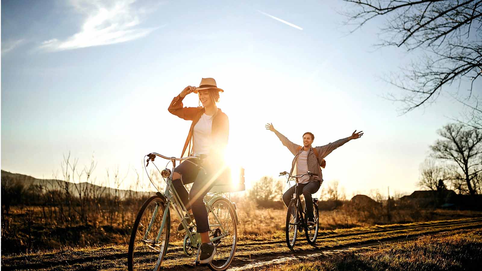 Couple driving on bicycle in nature, enjoying the sun