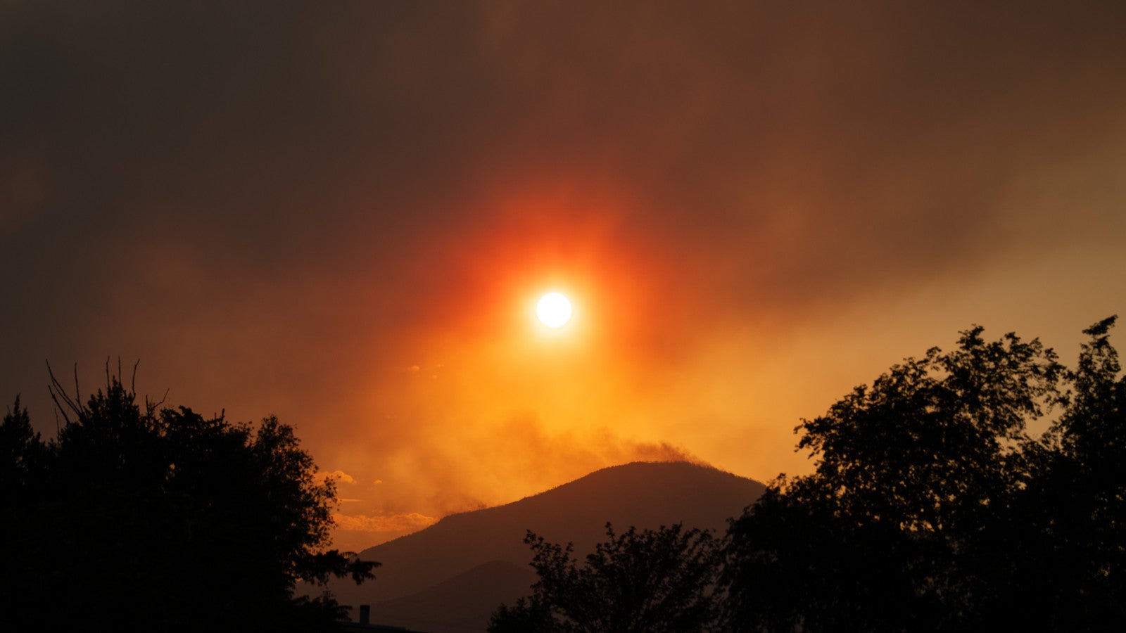 22.06.2026, USA, Saratoga Springs: Von Santaquin aus ist der Rauch des &bdquo;Iron Fire&ldquo; bei Sonnenuntergang &uuml;ber den East-Tintic-Bergen im Zentrum von Utah zu sehen. Foto: Charles Mcclintock Wilson/ZUMA Press Wire/dpa