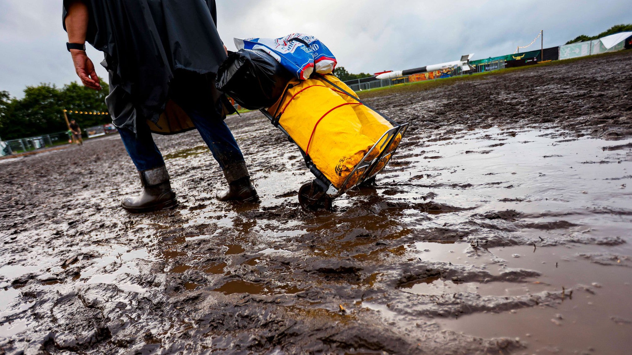 02.08.2025, Schleswig-Holstein, Wacken: Ein Festivalbesucher zieht sein Gep&auml;ck durch den Matsch beim Wacken Open Air. Das Wacken Open Air (WOA) findet vom 30. Juli bis 2. August statt und gilt als gr&ouml;&szlig;tes Heavy-Metal-Festival der Welt. (Frank Molter/dpa)