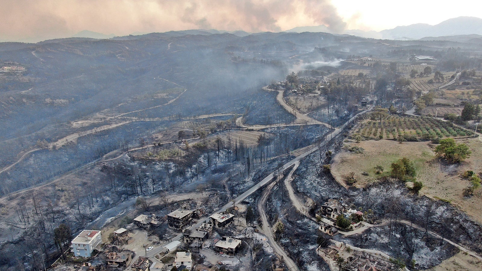 An aerial photo shows destroyed houses in a village as wildfire continue to rage the forests near the Mediterranean coastal town of Manavgat, Antalya, Turkey, Thursday, July 29, 2021. Authorities evacuated homes in southern Turkey as a wildfire fanned by strong winds raged through a forest area near the Mediterranean coastal town of Manavgat. District governor Mustafa Yigit said residents of four neighborhoods were moved out of the fire&rsquo;s path as firefighters worked to control the blaze that broke out Wednesday. It was not immediately clear what caused the fire but authorities said nearby tourist resorts were not affected. (Suat Metin/IHA via AP)