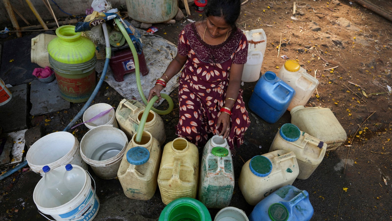22.03.2023, Indien, Hyderabad: Eine Frau bef&uuml;llt in einem Slum am Weltwassertag Kanister mit Wasser aus einem &ouml;ffentlichen Wasserhahn. Foto: Mahesh Kumar A./AP/dpa 