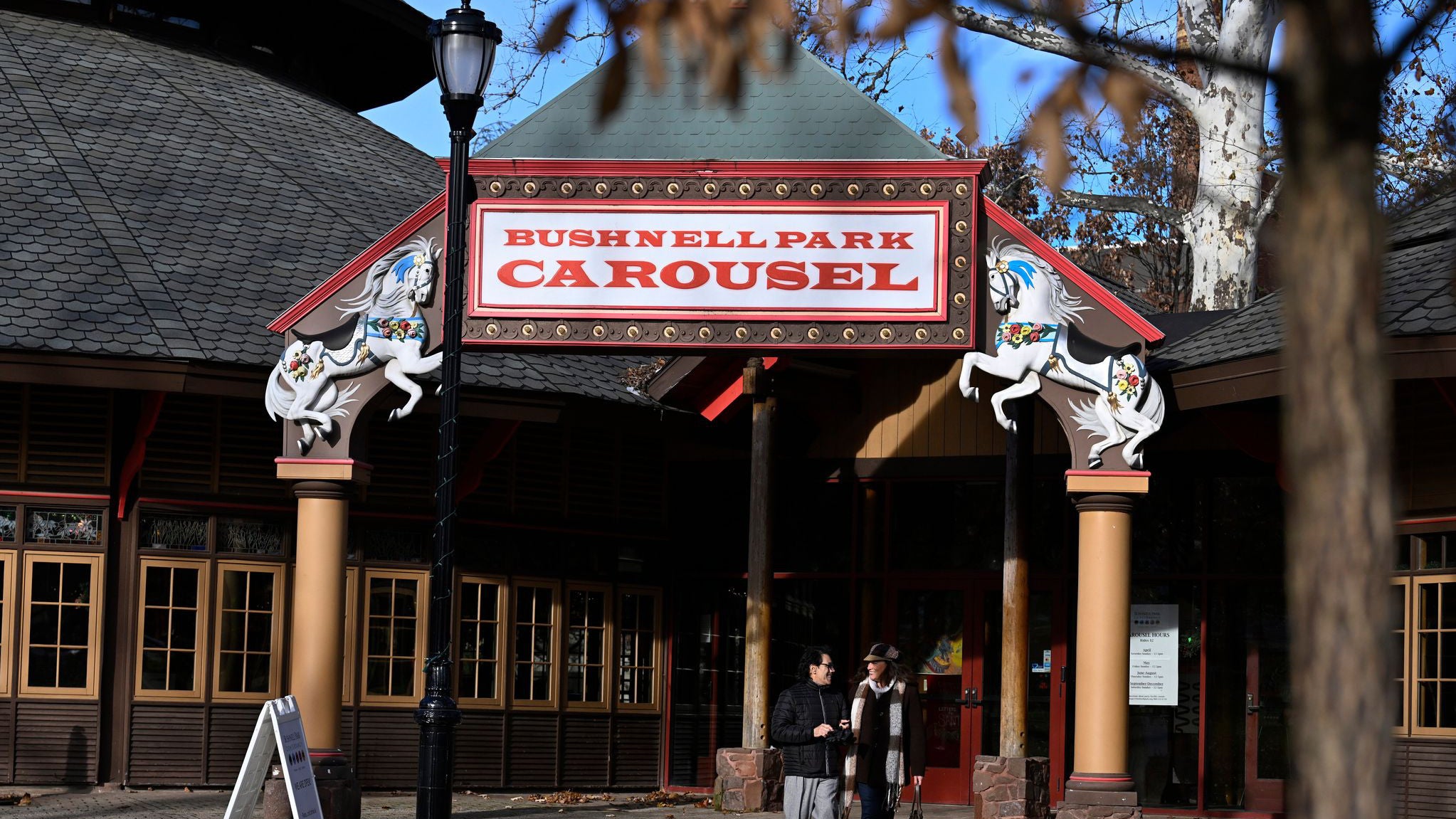 5. Dezember 2025, Hartford, Connecticut: Christina und Raul Nieves aus Windsor Locks besuchen das Bushnell Park Carousel. Szenen aus dem Hallmark-Film &bdquo;Ghost of Christmas Always&ldquo; wurden an diesem Karussell gedreht. (AP Photo/Jessica Hill)
