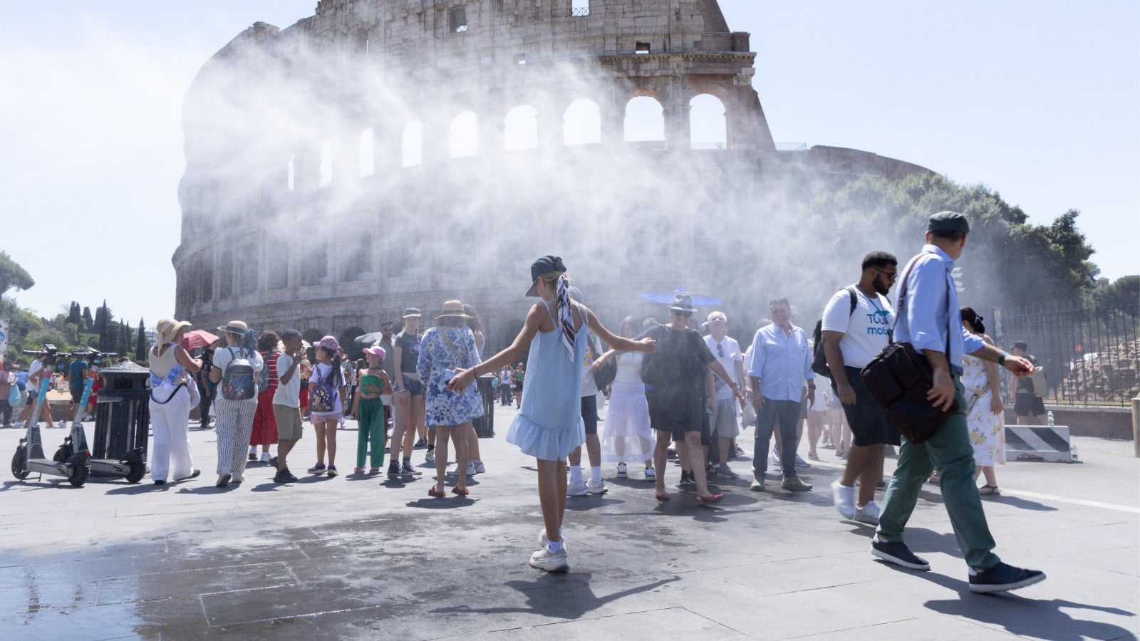 15.07.2026, Italien, Rom: Touristen suchen vor dem Kolosseum in Rom unter dem Spr&uuml;hnebel Abk&uuml;hlung. Foto: Matteo Nardone/IPA via ZUMA Press/dpa