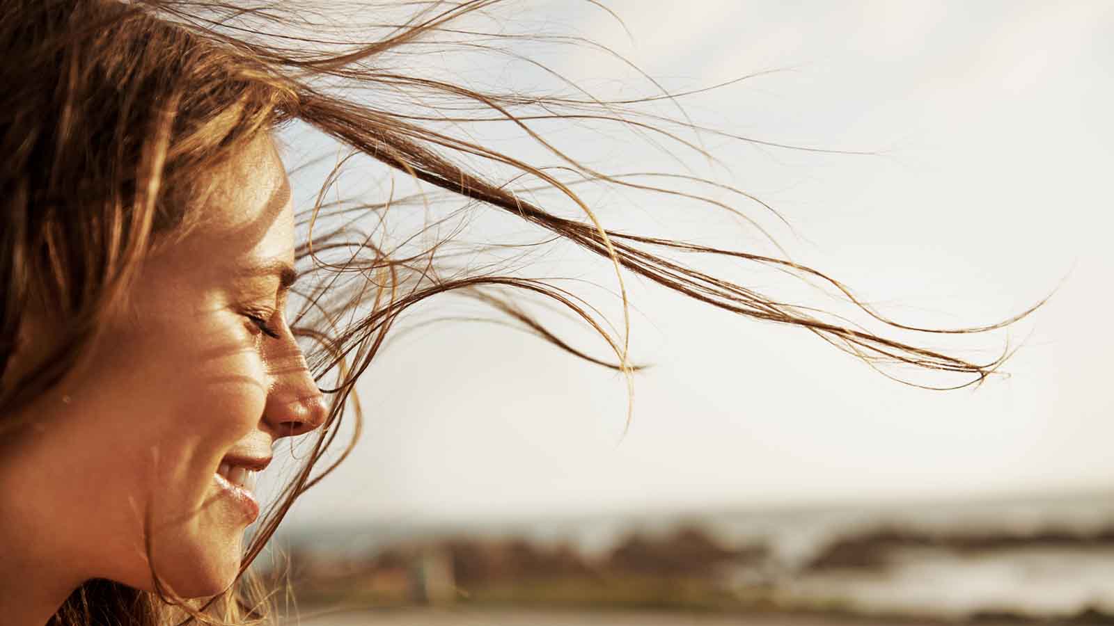Cropped view of a young woman with the wind in her hair