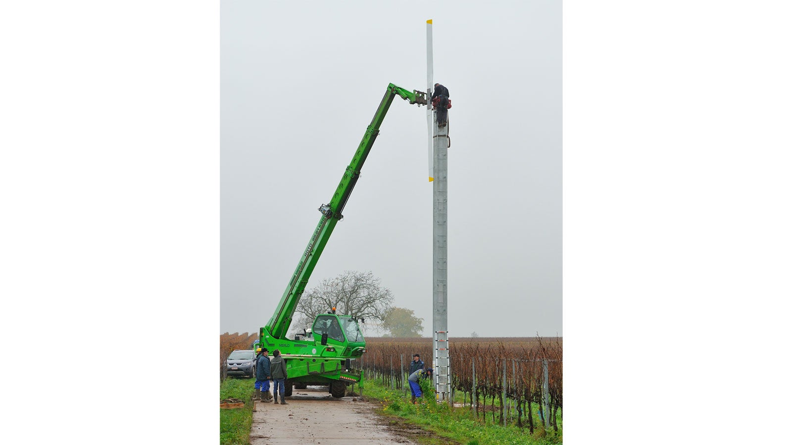 ARCHIV - 13.11.2013, Rheinland-Pfalz, Neustadt an der Weinstra&szlig;e: Arbeiter montieren in einem Weinberg bei Neustadt an der Weinstra&szlig;e (Rheinland-Pfalz) ein Windrad. Durch die Windr&auml;der soll Bodenfrost in den Weinbergen verhindert werden. (zu dpa: Wie Luftwirbel im Weinberg dem Frost ein Schnippchen schlagen) Foto: picture alliance / dpa