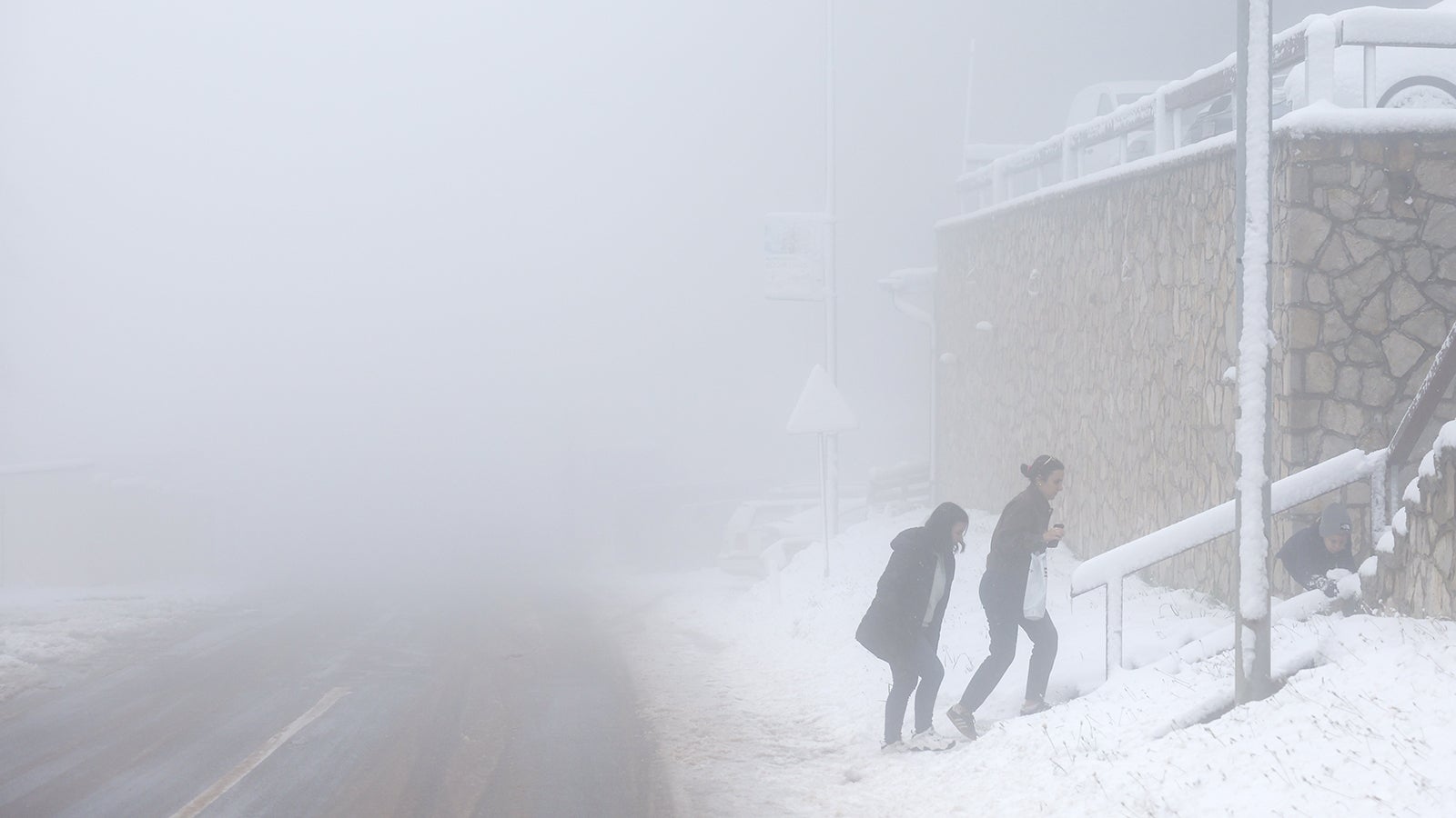 Leute gehen auf der Stra&szlig;e in Jahorina nahe der bosnischen Hauptstadt Sarajevo nach heftigen Schneef&auml;llen. (AP Photo/Armin Durgut)