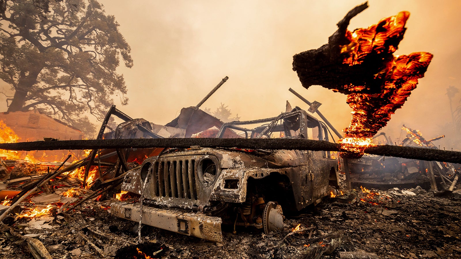 Ein ausgebrannter Wagen steht vor den Tr&uuml;mmern eines abgebrannten Hauses in der N&auml;he der kalifornischen Stadt Camarillo. Derzeit lodern Waldbr&auml;nde an beiden K&uuml;sten der USA (AP Photo/Ethan Swope)
