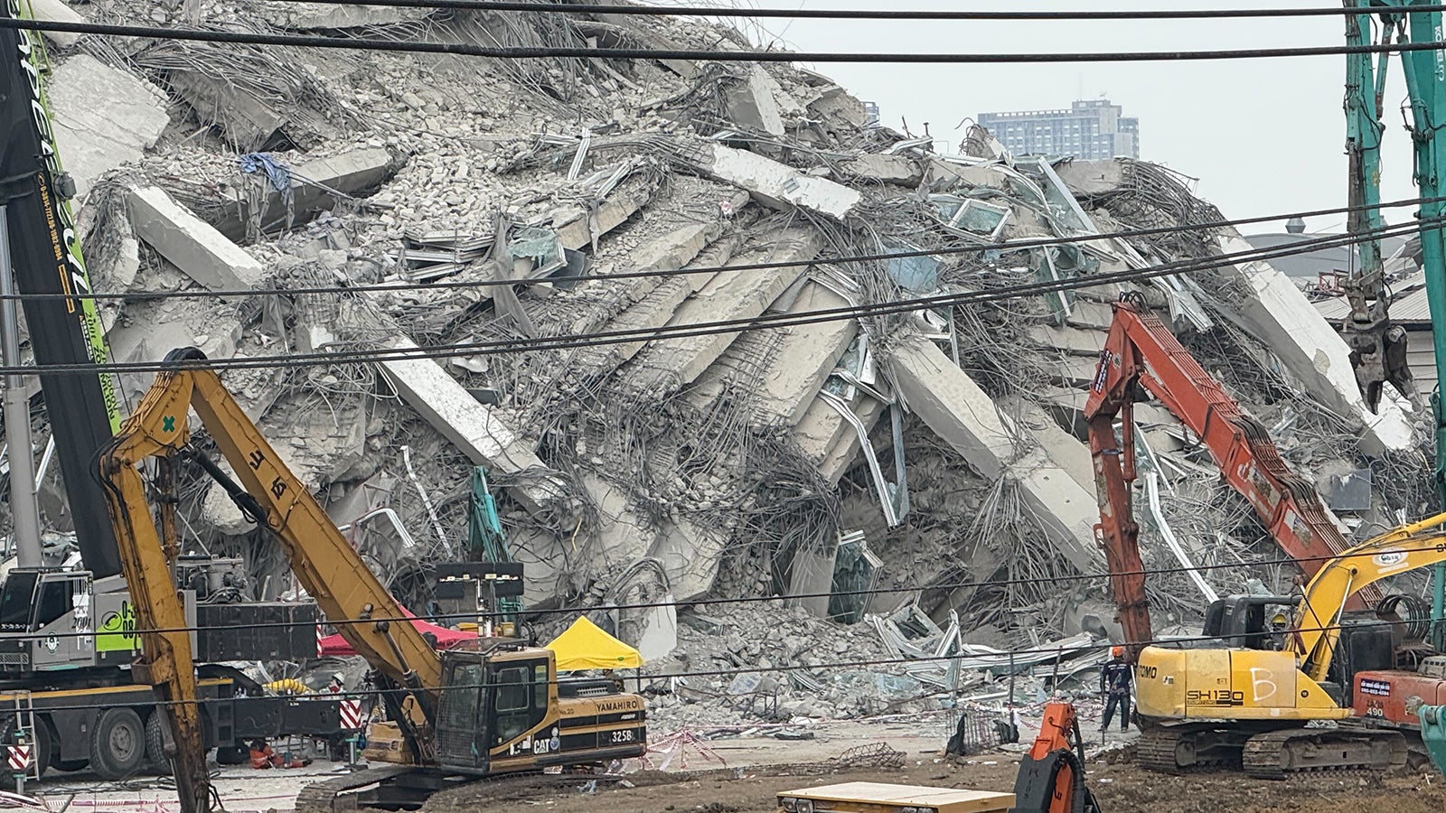 Gut zwei Tage nach einem Erdbeben versuchen Helfer weiter versch&uuml;ttete Menschen aus den Tr&uuml;mmern eines Hochhaus zu bergen. Dabei kommen auch Bagger zum&nbsp;Einsatz. Unter den Tr&uuml;mmern des Rohbaus des Wolkenkratzers werden weiter Menschen vermutet. Foto: Carola Frentzen/dpa