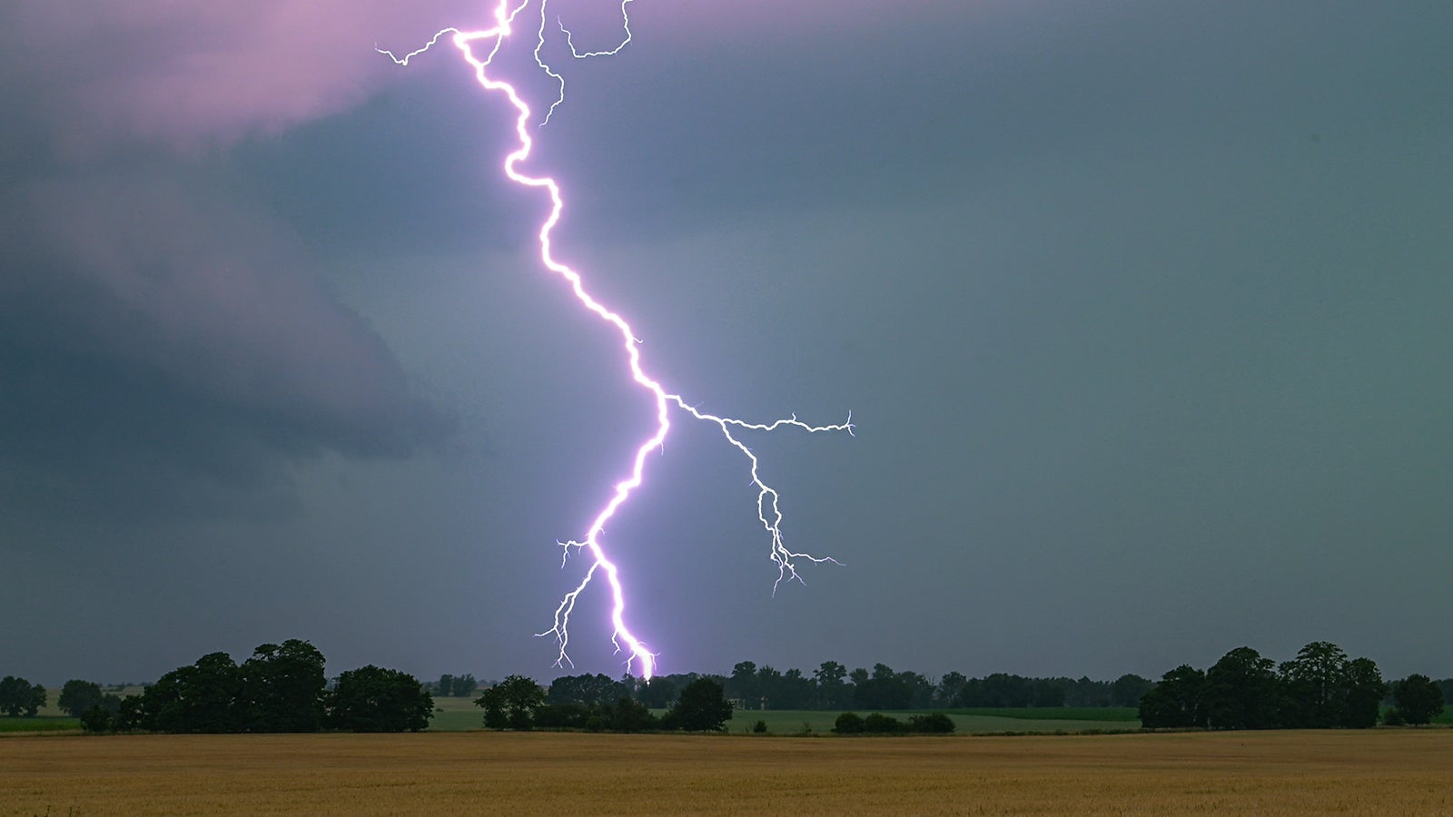 ARCHIV - 21.06.2024, Brandenburg, Heinersdorf: Ein Blitz leuchtet &uuml;ber einer Landschaft auf. (zu dpa: &laquo;Blitz, Donner und Schauer in Berlin und Brandenburg&raquo;) Foto: Patrick Pleul/dpa +++ dpa-Bildfunk +++