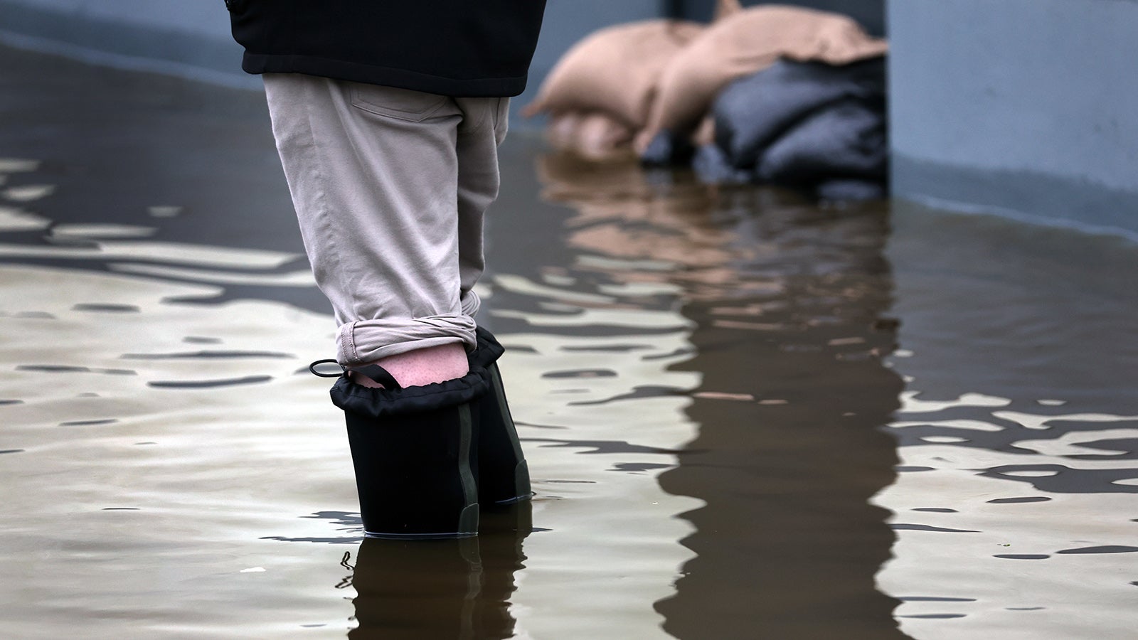 03.06.2024, Bayern, Burgau: Ein Anwohner steht mit Gummistiefeln im Hochwasser der Mindel. Foto: Karl-Josef Hildenbrand/dpa +++ dpa-Bildfunk +++