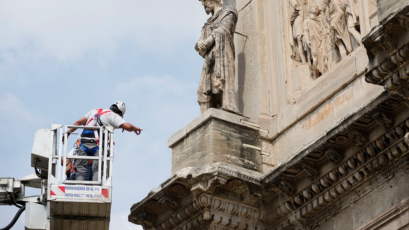Ein Arbeiter steht auf einem Kran neben dem Konstantinsbogen. Ein schweres Sommerunwetter hat am Dienstag, 3. September 2024 Teile der italienischen Hauptstadt unter Wasser gesetzt. Dabei hat ein Blitz in das antike r&ouml;mischen Bauwerk in der N&auml;he des Kolosseums eingeschlagen. Foto: Andrew Medichini/AP/dpa +++ dpa-Bildfunk +++