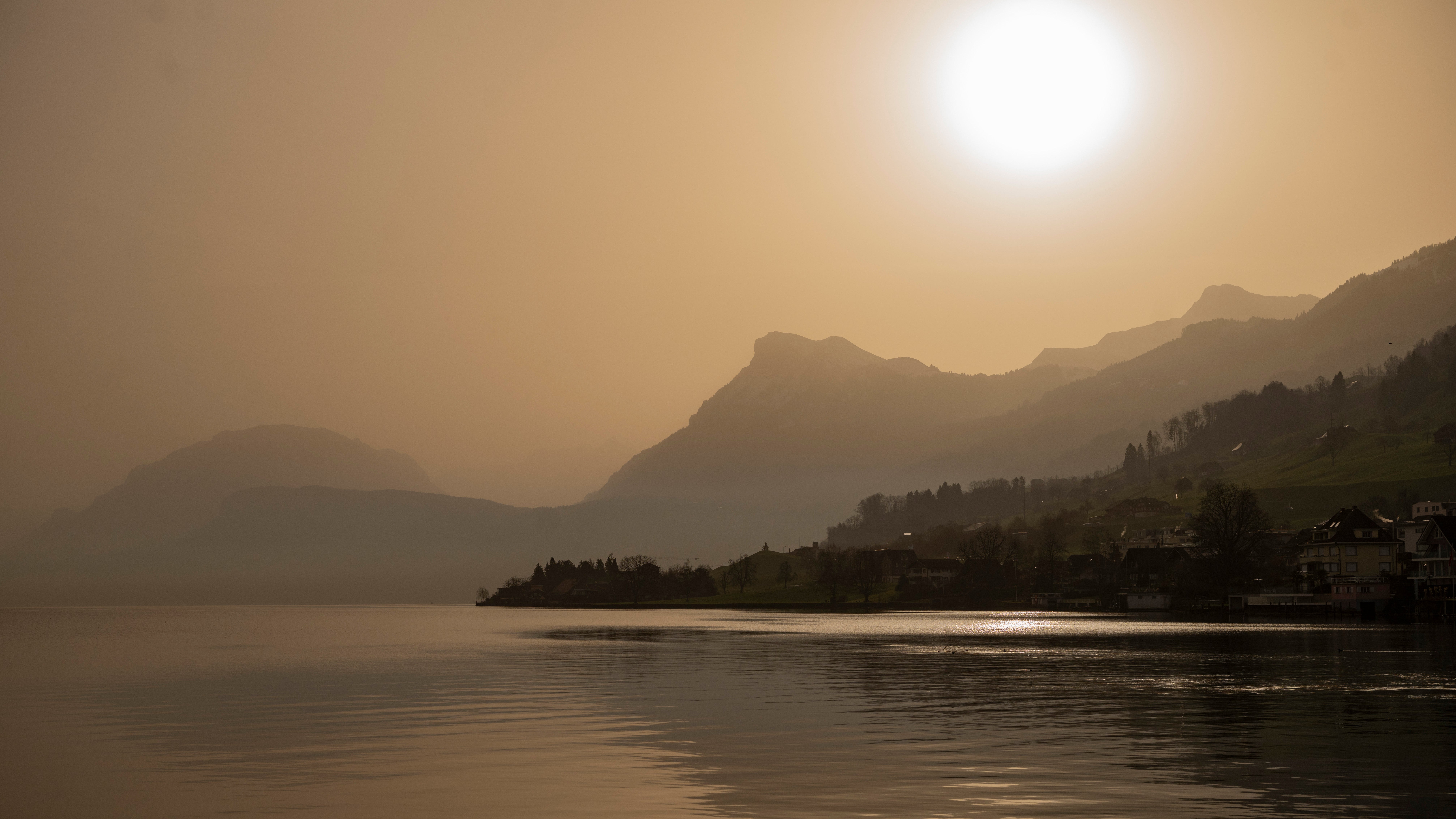 06.03.2026, Schweiz, Buochs: Die Landschaft des Vierwaldst&auml;ttersees bei Buochs erscheint in besonderen Farben, wenn Saharasand den Himmel orange f&auml;rbt und eine besondere Lichtstimmung erzeugt. Foto: Urs Flueeler/KEYSTONE/dpa +++ dpa-Bildfunk +++