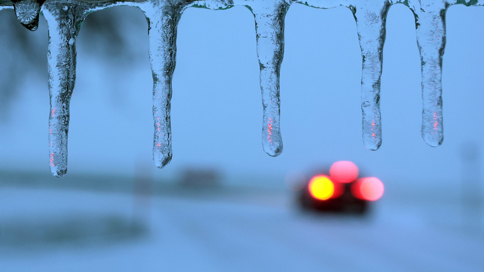 16.12.2022, Bayern, Marktoberdorf: Ein Auto f&auml;hrt am fr&uuml;hen Morgen im Schneetreiben hinter Eiszapfen. Foto: Karl-Josef Hildenbrand/dpa +++ dpa-Bildfunk +++