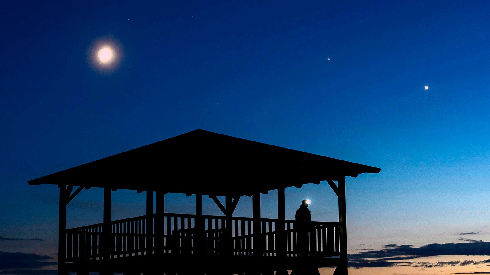 ARCHIV - 21.06.2015, Ungarn, Salgotarjan: Der Mond (l-r), der Jupiter und die Venus sind am Nachthimmel &uuml;ber einem Aussichtspunkt bei Salgotarjan, in der N&auml;he von Budapest, zu sehen. Zwei Planeten bestimmen den Abendhimmel und die Fr&uuml;hlingssternbilder ziehen auf. In jedem Fall aber sollte man im M&auml;rz die Zeitumstellung nicht verpassen. Foto: Peter Komka/MTI/dpa +++ dpa-Bildfunk +++