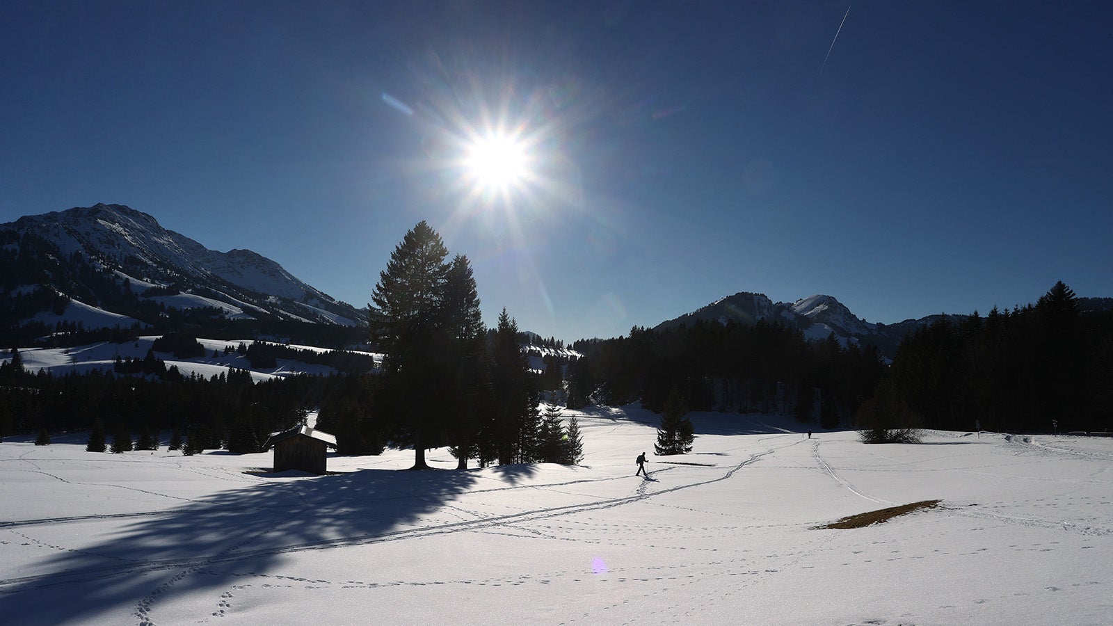 ARCHIV - 13.02.2022, Bayern, Bad Hindelang: Schneeschuhwanderer gehen im Ortsteil Unterjoch im Sonnenschein durch die winterliche Landschaft. (zu dpa &laquo;Winter in Bayern k&auml;lter als anderswo, aber mit besonders viel Sonne&raquo;) Foto: Karl-Josef Hildenbrand/dpa +++ dpa-Bildfunk +++