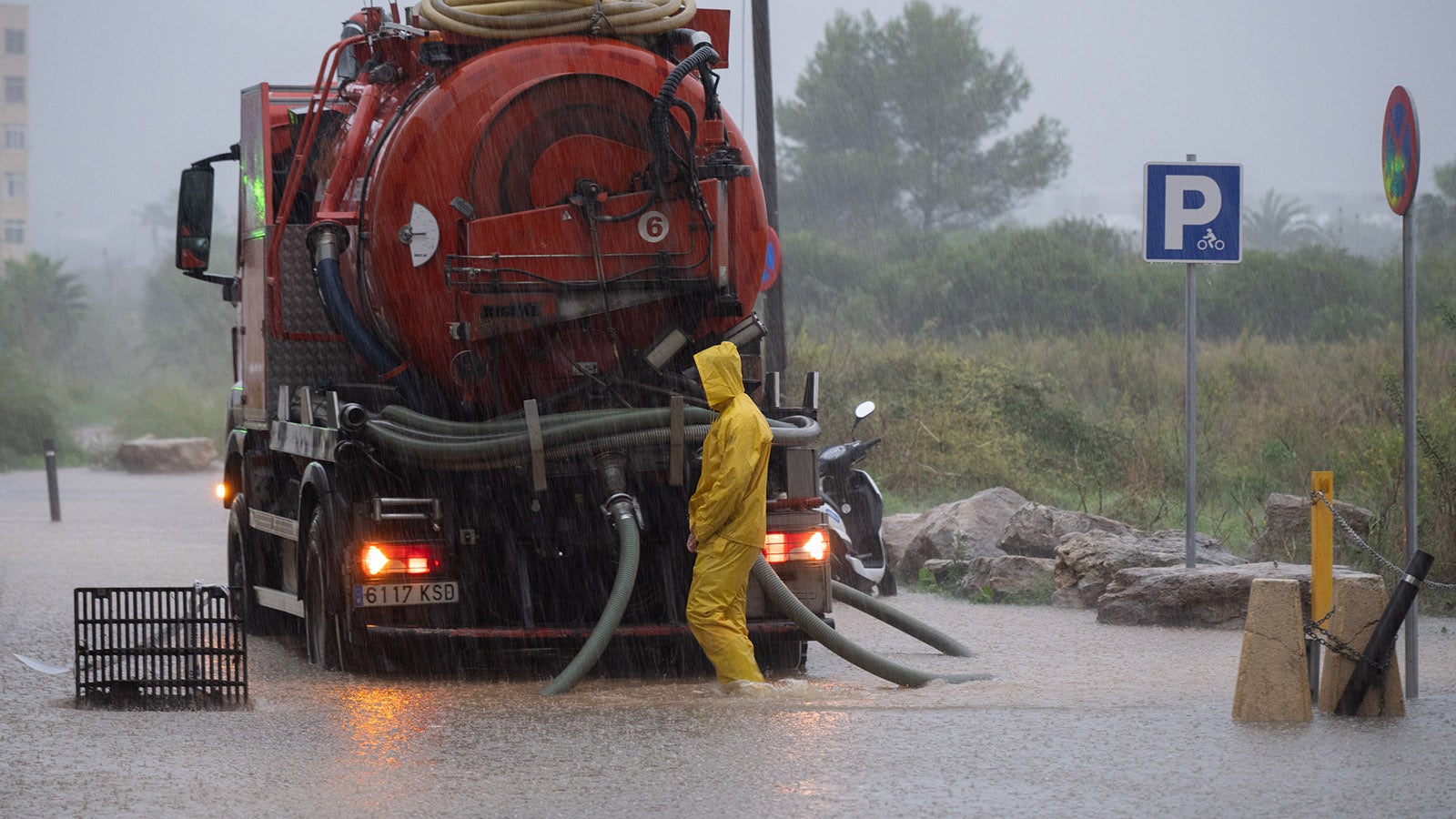 19.10.2026, Spanien, Ibiza: Ein Arbeiter steht hinter einem Saugfahrzeug auf einer &uuml;berschwemmten Stra&szlig;e. Regenf&auml;lle haben in der Mittelmeerregion Spaniens zu &Uuml;berschwemmungen gef&uuml;hrt. Auf Ibiza wurden elf Vorf&auml;lle gemeldet. Das Sturmtief &laquo;Adam&raquo; hatte zuvor mit extremen Niederschl&auml;gen bereits am Wochenende Chaos auf dem spanischen Festland verursacht Foto: Germ&aacute;n Lama/EUROPA PRESS/dpa +++ dpa-Bildfunk +++