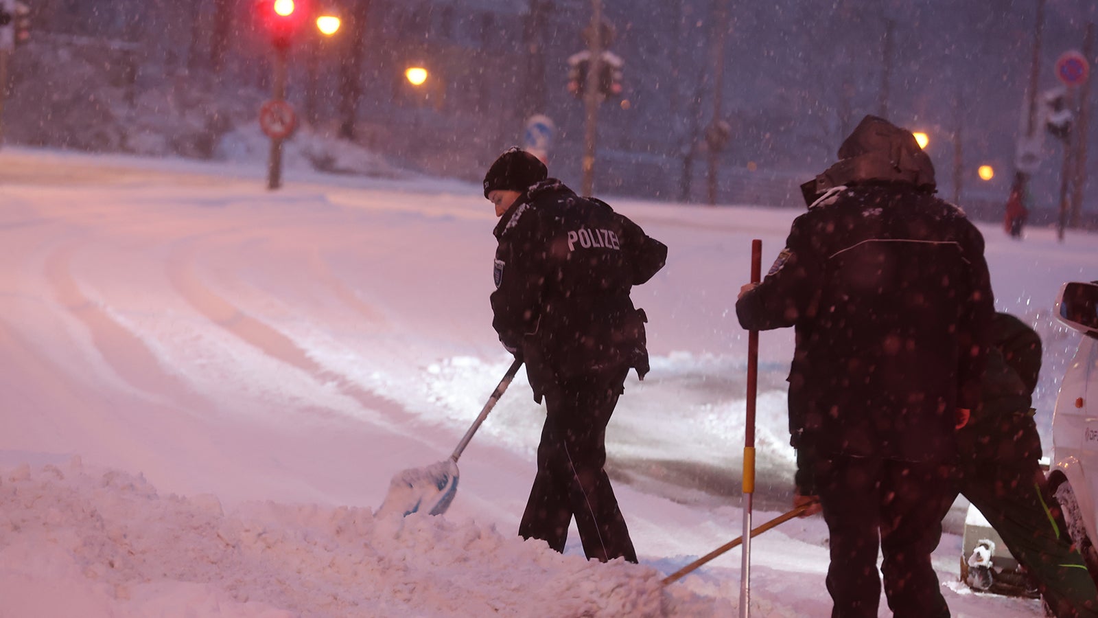 09.01.2026, Th&uuml;ringen, Gera: Polizeibeamte schaufeln Schnee von einer Stra&szlig;e. Foto: Bodo Schackow/dpa +++ dpa-Bildfunk +++