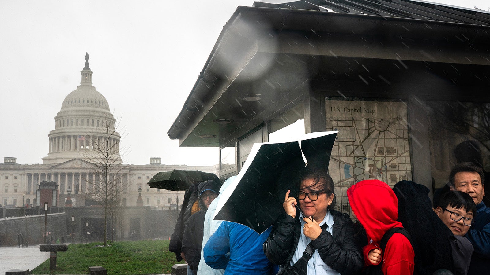 In Washington D. C. suchen Menschen am Capitol Hill Schutz vor Starkregen. 16. M&auml;rz 2026. (AP Photo/Nathan Howard)