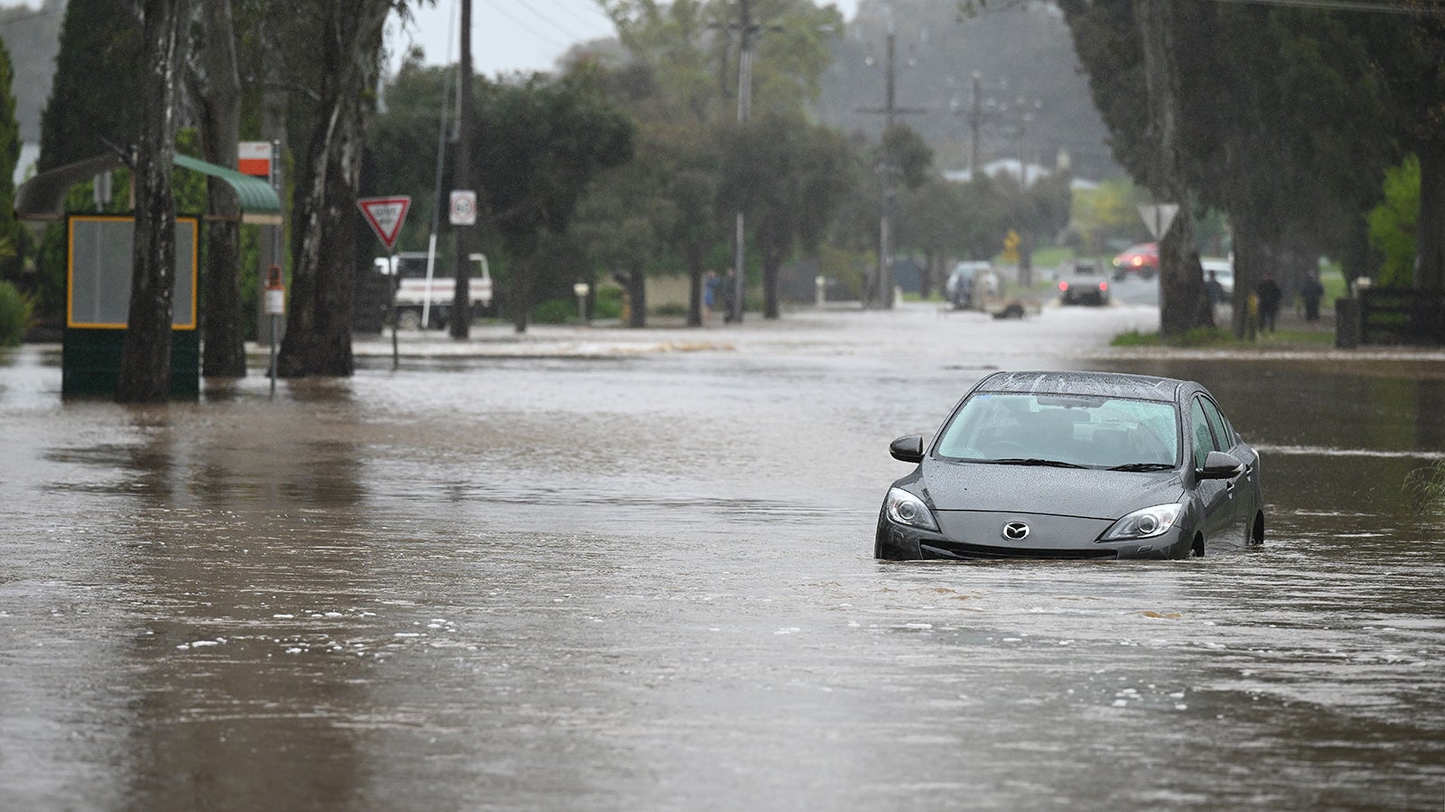 A partly submerged car is seen in flood water in Ascot, a northern suburb of Bendigo in Victoria, Thursday, October 13, 2022. Victoria is on alert for heavy rains and flooding, with a severe weather warning issued. (AAP Image/James Ross) NO ARCHIVING
