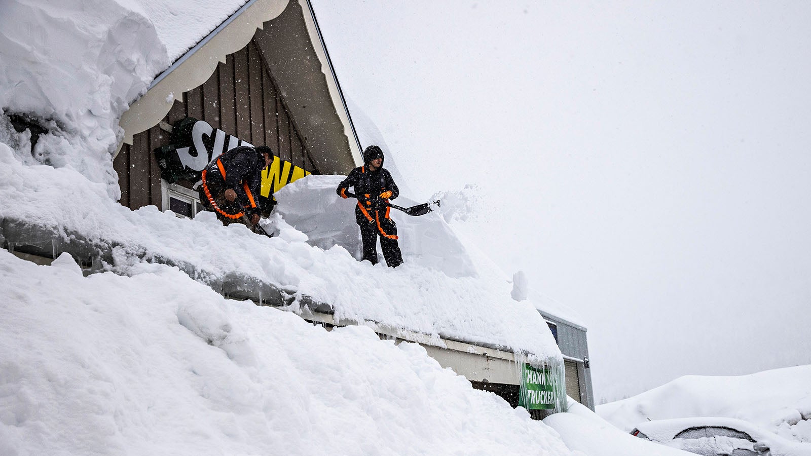 Workers remove snow off the roof of a Subway sandwich store near Cisco Grove, Calif., Thursday, March 9, 2023. (Stephen Lam/San Francisco Chronicle via AP)