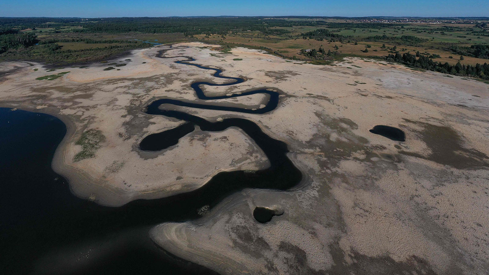ARCHIV - 03.08.2022, Frankreich, Bouverans: Diese Luftaufnahme zeigt den ausgetrockneten &laquo;Lac de l'Entonnoir&raquo;, auch bekannt als &laquo;Lac du Bouverans&raquo;, in Bouverans, Ostfrankreich. (zu dpa: &laquo;Frankreich f&uuml;rchtet wegen Trockenheit im Winter zweiten D&uuml;rre-Sommer&raquo;) Foto: Sebastien Bozon/AFP/dpa +++ dpa-Bildfunk +++