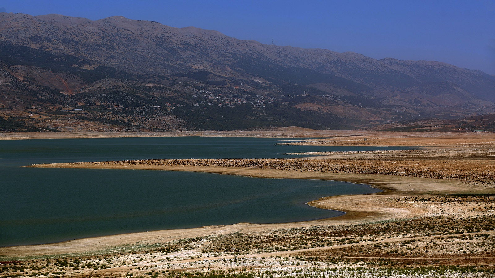 15.08.2025, Libanon, Qaraoun: Ein Blick auf den niedrigen Wasserstand des Qaraoun-Sees, des gr&ouml;&szlig;ten libanesischen Stausees am Litani-Fluss. Der Wasserstand ist auf einen historischen Tiefstand gesunken. Experten sprechen von der schlimmsten D&uuml;rre, die die Landwirtschaft, die Stromerzeugung und die Wasserversorgung der Haushalte bedroht. Eine intensive Hitzewelle und ein ungew&ouml;hnlich trockener Winter haben diesen drastischen R&uuml;ckgang verursacht. (zu dpa: &laquo;Teure Eintrittspreise: Im Libanon sind Strandbesuche Luxus&raquo;) Foto: Marwan Naamani/dpa +++ dpa-Bildfunk +++