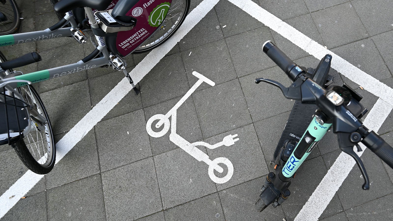 ARCHIV - 09.02.2023, Hessen, Frankfurt/Main: Ein Piktogramm auf dem Asphalt weist an der Stiftstra&szlig;e nahe des Eschenheimer Turmes auf eine Abstellfl&auml;che f&uuml;r E-Scooter hin. Die Stadt Frankfurt setzt seit einem Jahr auf kostenpflichtige Sondernutzungserlaubnisse f&uuml;r die Verleiher der Scooter. Damit wird das Abstellen etwa auf Gr&uuml;nfl&auml;chen, Friedh&ouml;fen, Br&uuml;cken und Spielpl&auml;tzen verboten. (Zu dpa: "Abstellchaos bei E-Scootern - ein Ende in Sicht?") Foto: Arne Dedert/dpa +++ dpa-Bildfunk +++