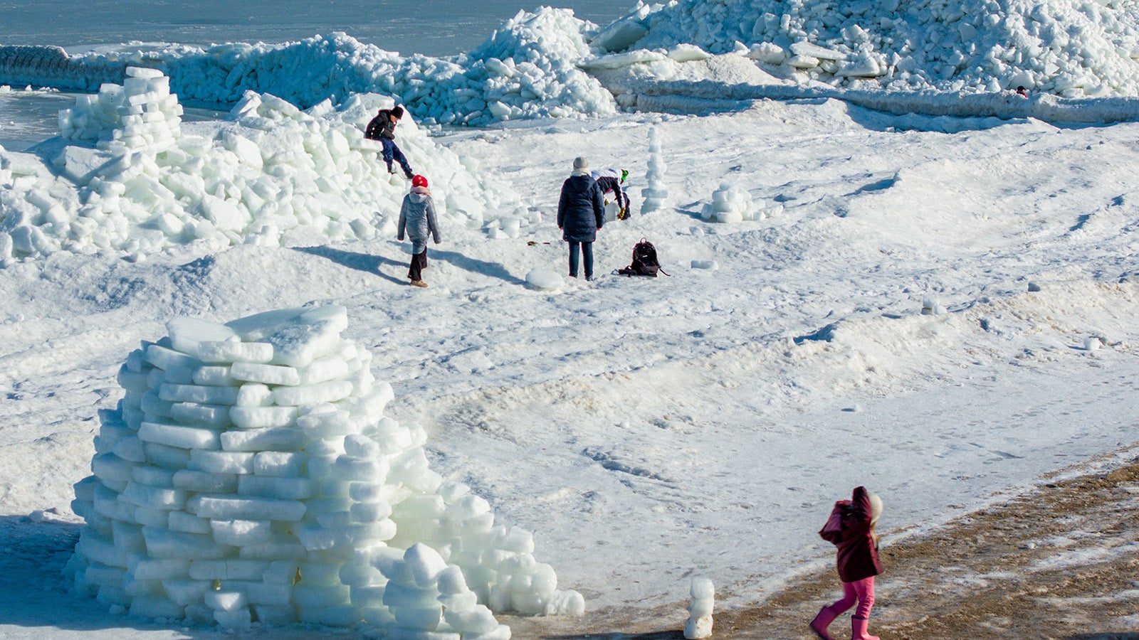 Urlauber klettern auf den meterhohen Eisbergen am Ostseestrand auf der Insel Usedom. Foto: Jens B&uuml;ttner/dpa