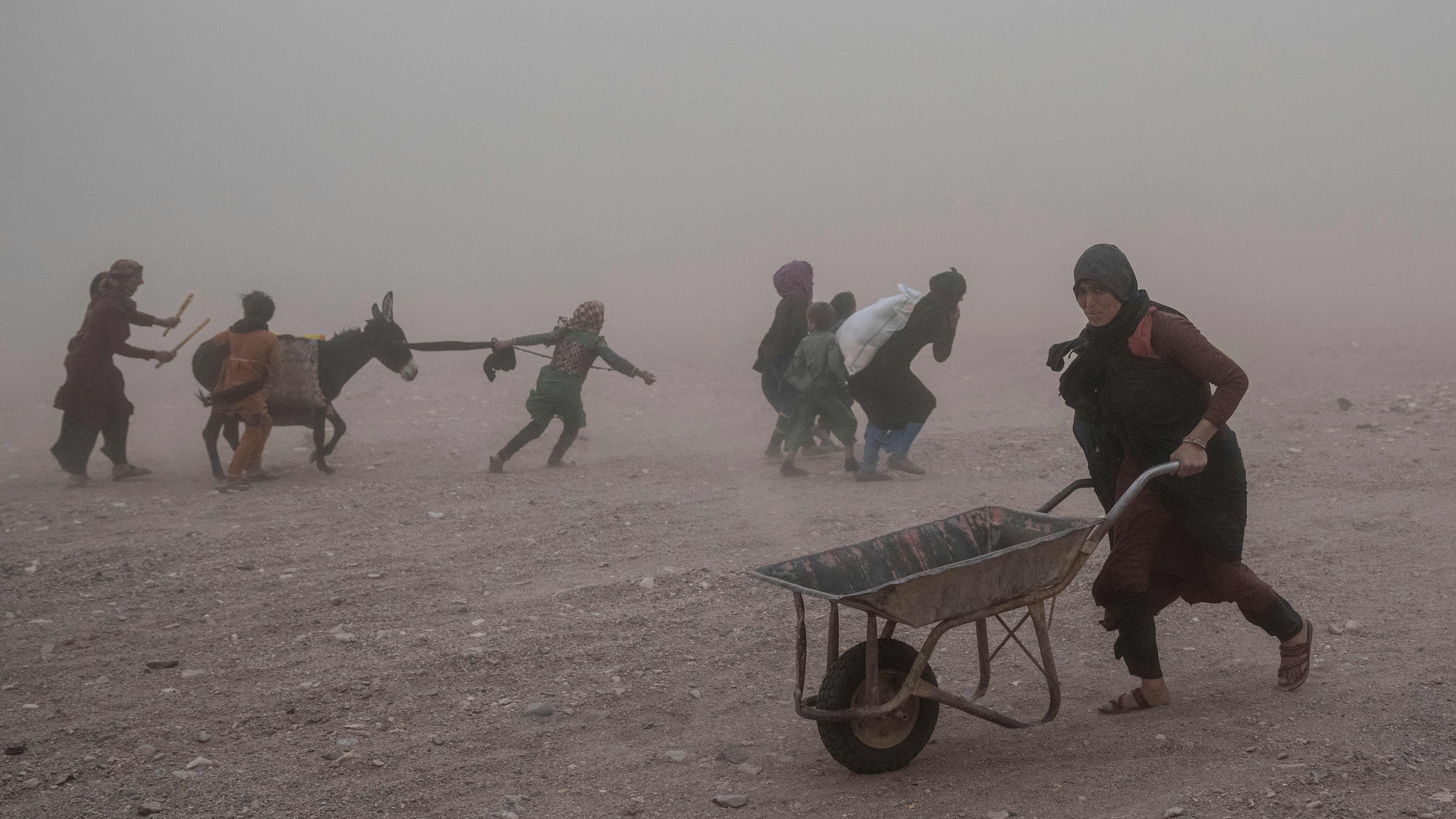 12.10.2023, Afghanistan, Herat: Afghanen erhalten Hilfsg&uuml;ter, w&auml;hrend im Dorf Chahak nach einem Erdbeben im Bezirk Zenda Jan in der Provinz Herat im Westen Afghanistans ein Sandsturm w&uuml;tet. Foto: Ebrahim Noroozi/AP +++ dpa-Bildfunk +++
