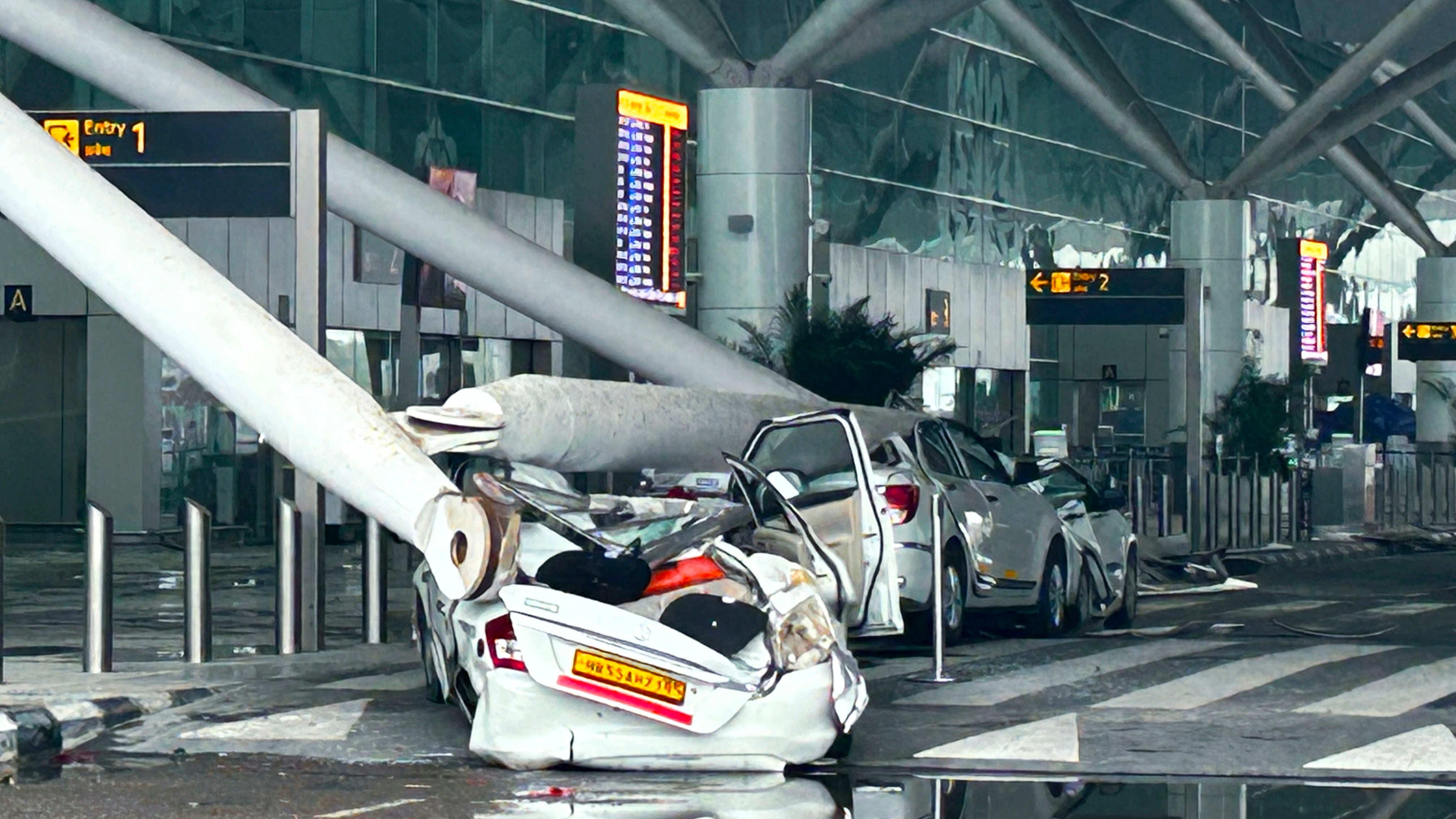 28.06.2024, Indien, Neu Delhi: Geparkte Fahrzeuge sind durch den Einsturz einer &Uuml;berdachung des Abflugterminals des internationalen Flughafens Indira Gandhi nach heftigen Monsunregenf&auml;llen besch&auml;digt worden. Foto: Uncredited/AP +++ dpa-Bildfunk +++