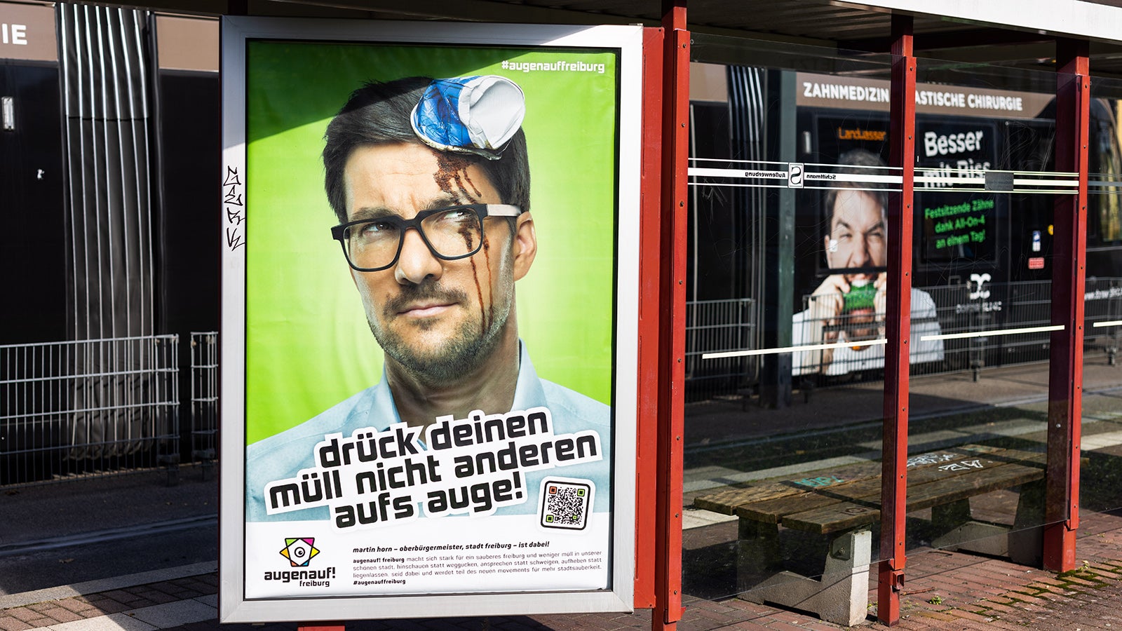 PRODUKTION - 18.10.2022, Baden-W&uuml;rttemberg, Freiburg: Ein Plakat der Kampagne &laquo;augenauf! Freiburg&raquo; mit einem Bild von Oberb&uuml;rgermeister Martin Horn (parteilos) h&auml;ngt an einer Stra&szlig;enbahnhaltestelle in Freiburg. Die Kampagne soll zur Vermeidung von M&uuml;ll im Stadtbild anregen. (zu dpa: Freiburg k&auml;mpft gegen wilden M&uuml;ll - Plakataktion mit B&uuml;rgermeister) Foto: Philipp von Ditfurth/dpa - Nutzung nur nach schriftlicher Vereinbarung mit der dpa +++ dpa-Bildfunk +++