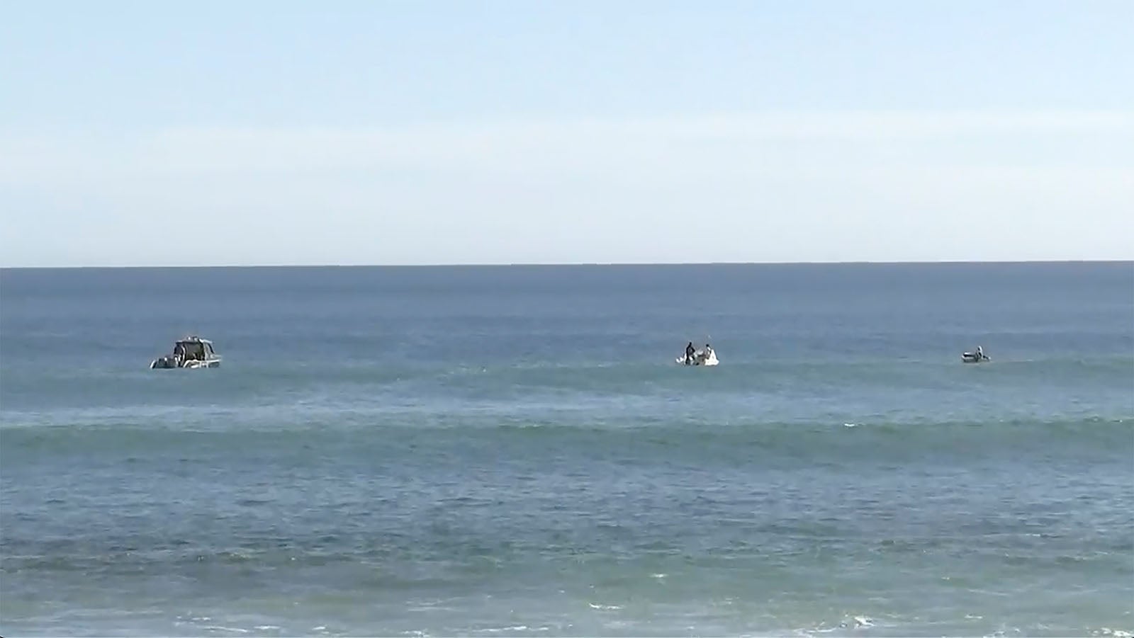 In this image from a video, searchers on boats conduct an operation in waters in Elliston, Australia Saturday, May 13, 2023. Police continued to search Monday for remains of a 46-year-old surfer who was attacked  by a shark off the south Australian coast two days earlier. (Australian Broadcasting Corp. via AP)