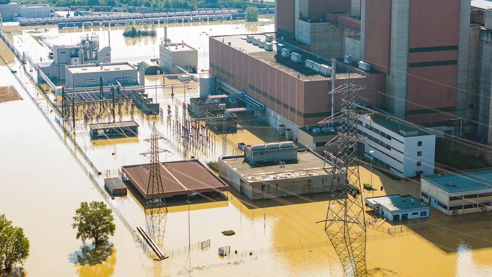 18.09.2024, &Ouml;sterreich, Erpersdorf: Das Kohle-Gas-Kraftwerk D&uuml;rnrohr ist volls&auml;ndig vom Wasser umschlossen und &uuml;berschwemmt. In &Ouml;sterreich geht das Hochwasser zwar leicht zur&uuml;ck, doch die Lage bleibt angespannt und es drohen weiter Dammbr&uuml;che und Erdrutsche. (Luftaufnahme mit einer Drohne) Foto: Christoph Reichwein/dpa +++ dpa-Bildfunk +++