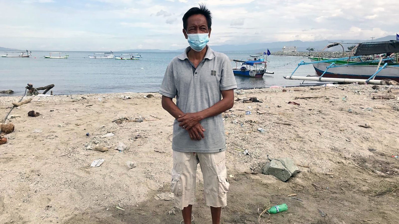 PRODUKTION - 25.01.2025, Indonesien, Palu: Jamal, 50, steht Ende Januar 2025 am Ufer des Talise Beach in der Bucht von Palu. Er ist einer von einem Dutzend Fischern, die im November 2020 beim Fischen in der Bucht von Palu einen Angriff eines 2,5 Meter langen Krokodils &uuml;berlebt haben. (zu dpa: &laquo;Krokodil gegen Mensch in Indonesien&raquo;) Foto: Muhammad Taufan/dpa +++ dpa-Bildfunk +++